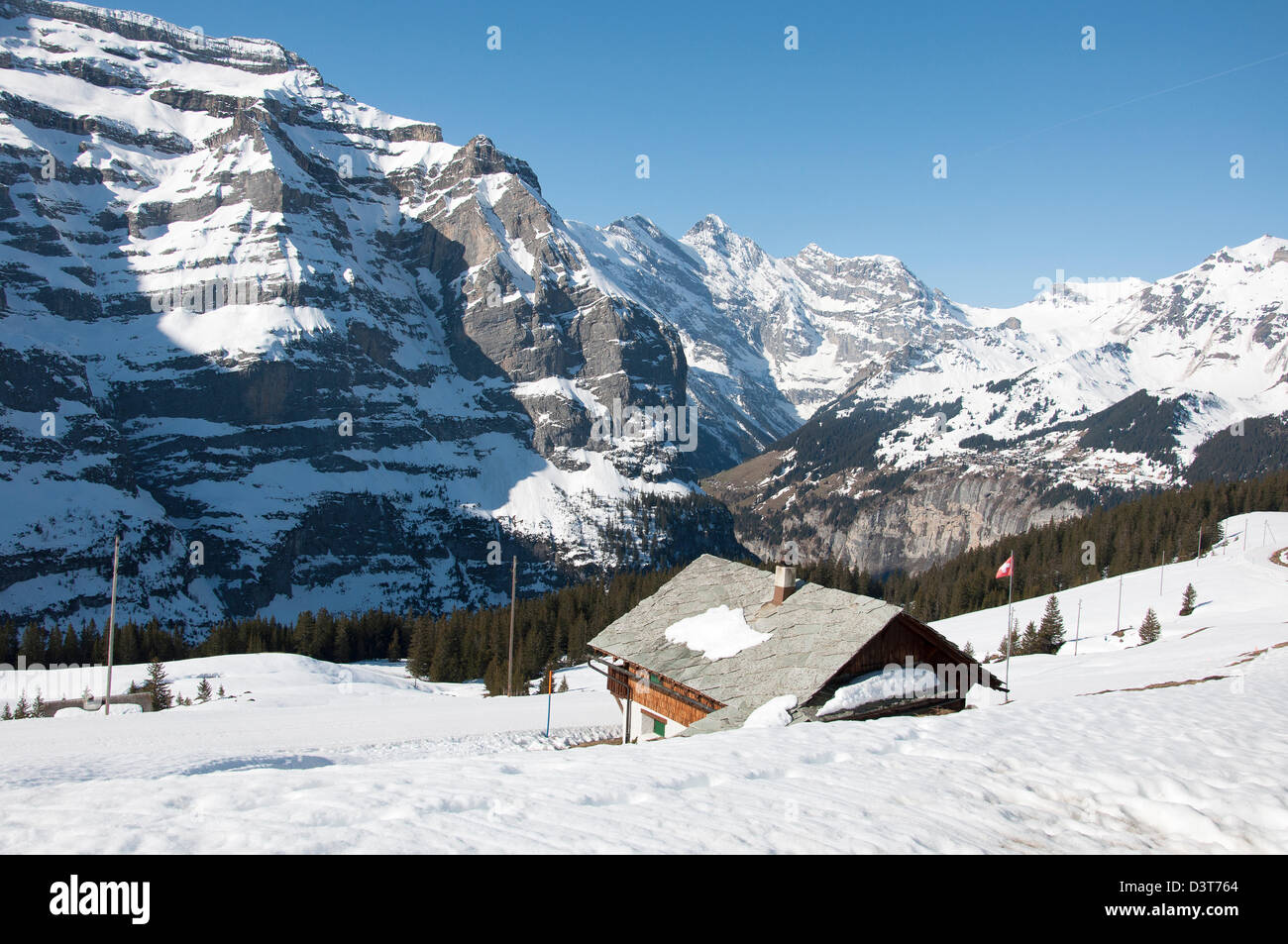 Eine verschneite Hütte, umgeben von schneebedeckten Schweizer Alpen Stockfoto