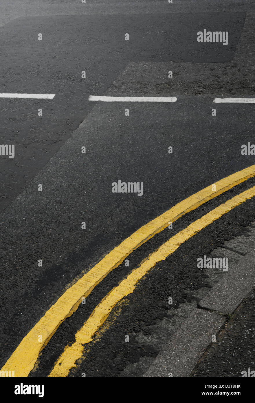 Gebogene doppelte gelbe Linien auf der Straße an einer Kreuzung, UK Stockfoto