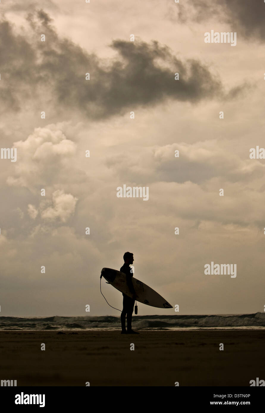 Surfer steht mit Blick auf Meer, St. Agnes, Cornwall, UK Stockfoto