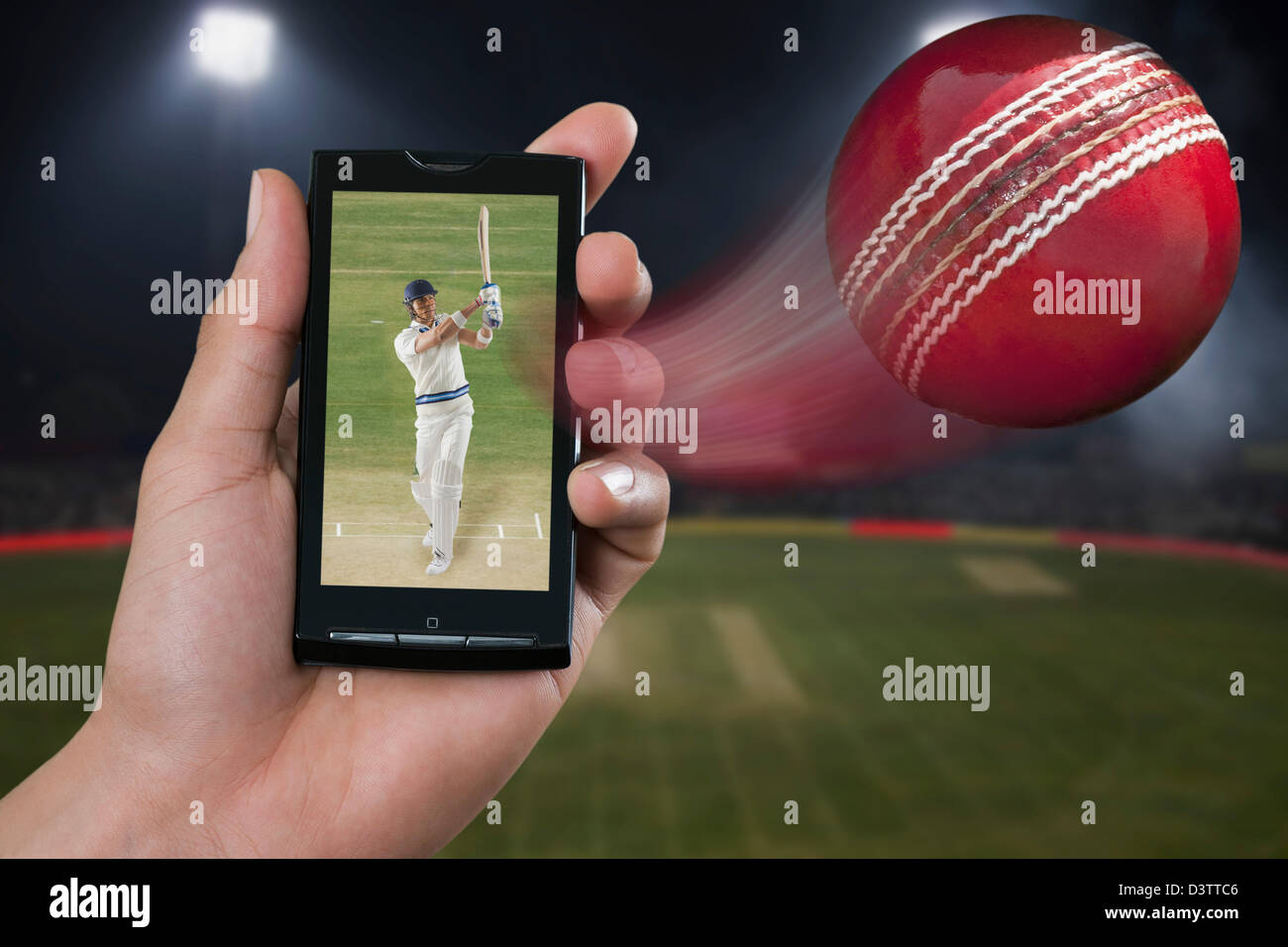 Mann beobachtet ein Cricket Spiel auf dem Handy Stockfoto