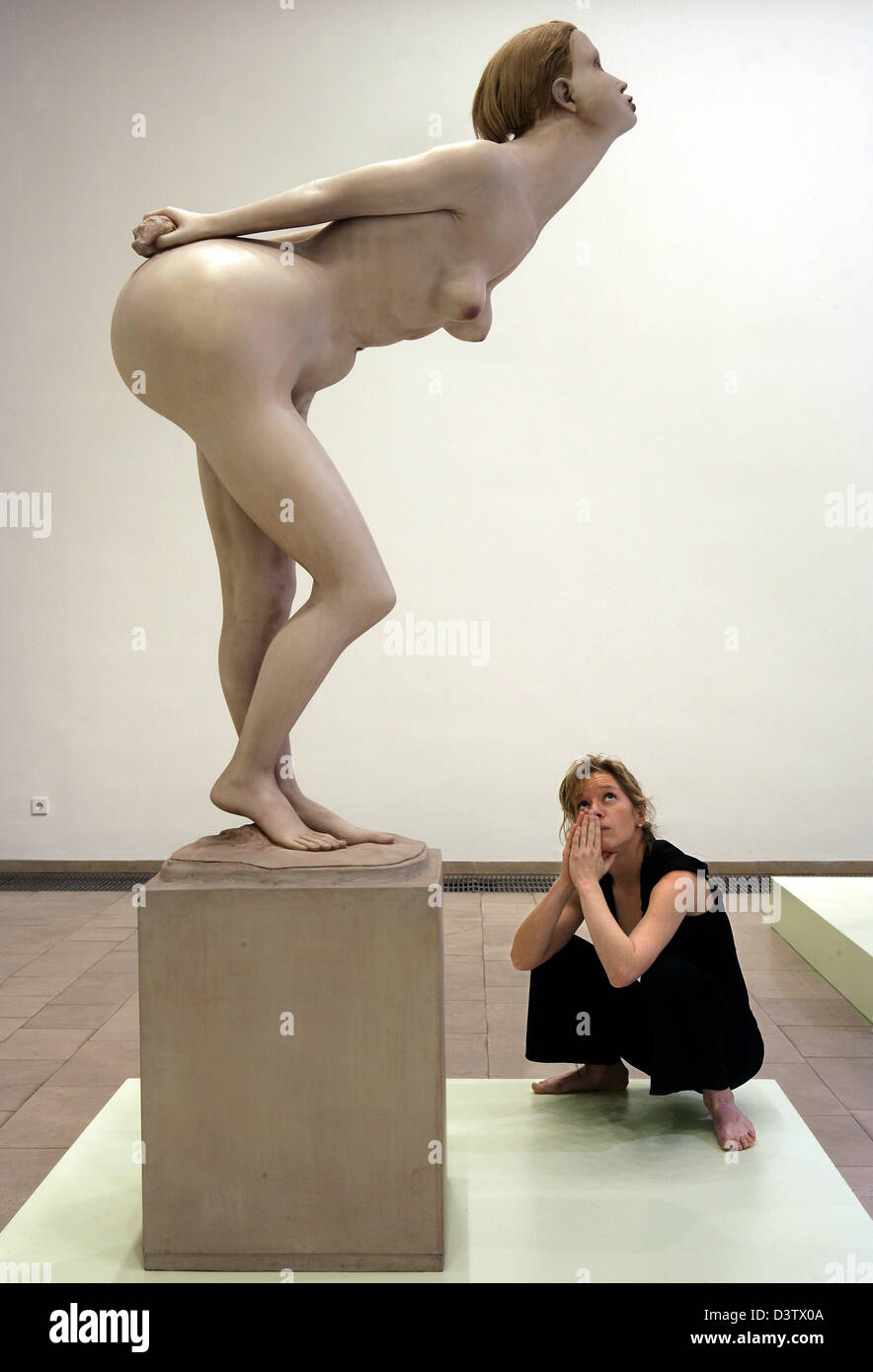 Ein Besucher schaut die bemalte Bronze-Skulptur "Biegen Girl" (1968-71) des britischen Künstlers Reg Butler im Gerhard Marcks-House in Bremen, Deutschland, Mittwoch, 22. November 2006. Die Kunstwerk sind Teil der Ausstellung "Reg Butler - anständige Sulpture", die vom 24. November 2006 bis 28. Februar 2007 in Bremen. Butler gehört die britischen Künstler, die neue Impulse für Sculp gab Stockfoto