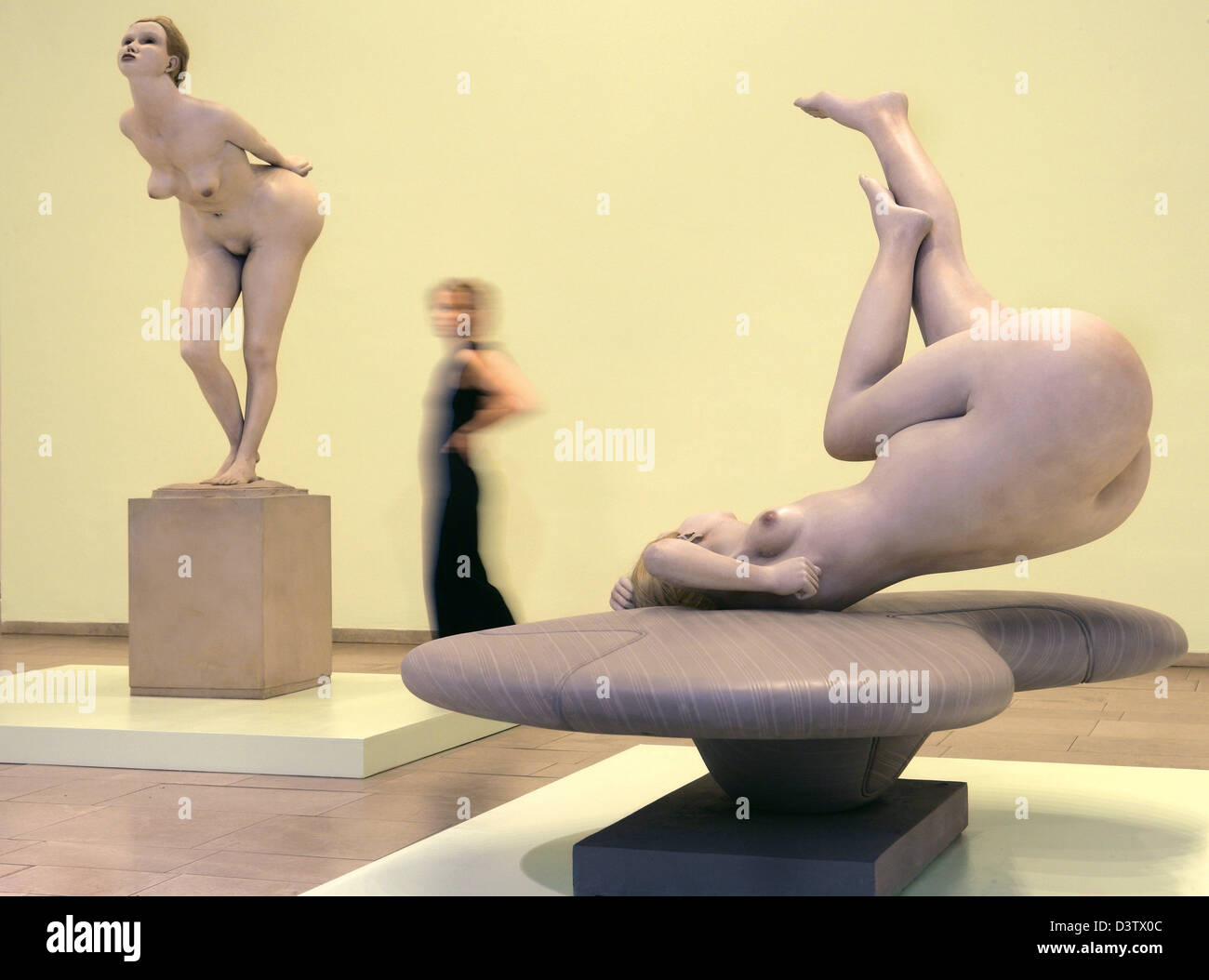 Ein Besucher schaut die bemalte Bronze Skulpturen 'biegen Girl"(1968-71, L) und"Girl auf einem langen Basis"(1968-72) des britischen Künstlers Reg Butler im Gerhard Marcks-House in Bremen, Deutschland, Mittwoch, 22. November 2006. Die Kunstwerke sind Bestandteil der Ausstellung "Reg Butler - anständige Sulpture", die vom 24. November 2006 bis 28. Februar 2007 in Bremen. Butler gehört die britisc Stockfoto