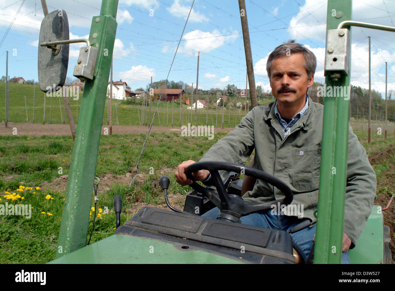 Hop Landwirt Peter Bentele verwendet seinen Traktor auf das Feld für den Anbau von Hopfen in Wellmutsweiler, Deutschland, 24. April 2004 vorzubereiten. Bentele wächst Hop nach Demeter-Richtlinien. Das Interesse an natürlichen Zutaten ist auf dem Vormarsch unter den Brauereien. Foto: Rolf Schultes Stockfoto