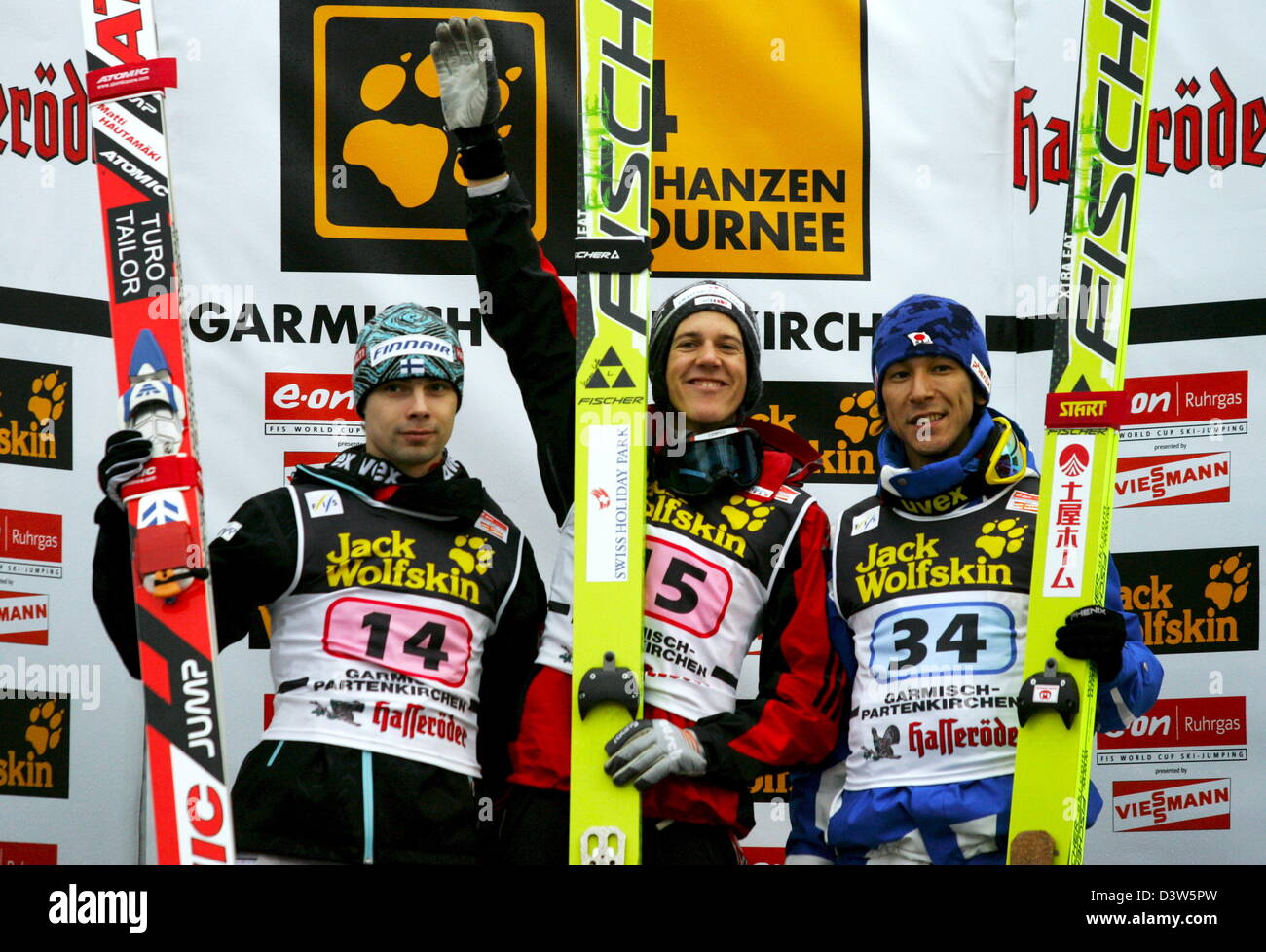 Skispringer (L-R) 2. platzierte finnische Matti Hautamaeki, Sieger Schweizer Andreas Küttel und Thrird platziert japanische Noriaki Kasai jubeln auf dem Podium in der zweiten Phase der 55. Vierschanzentournee in Garmisch-Partenkirchen, Deutschland, Sonntag, 1. Januar 2006. Aufgrund der stürmischen Winde und und regnerischen Bedingungen, die das traditionelle Silvester-springen der 4 Hügel wurde beendet, nach der Stockfoto