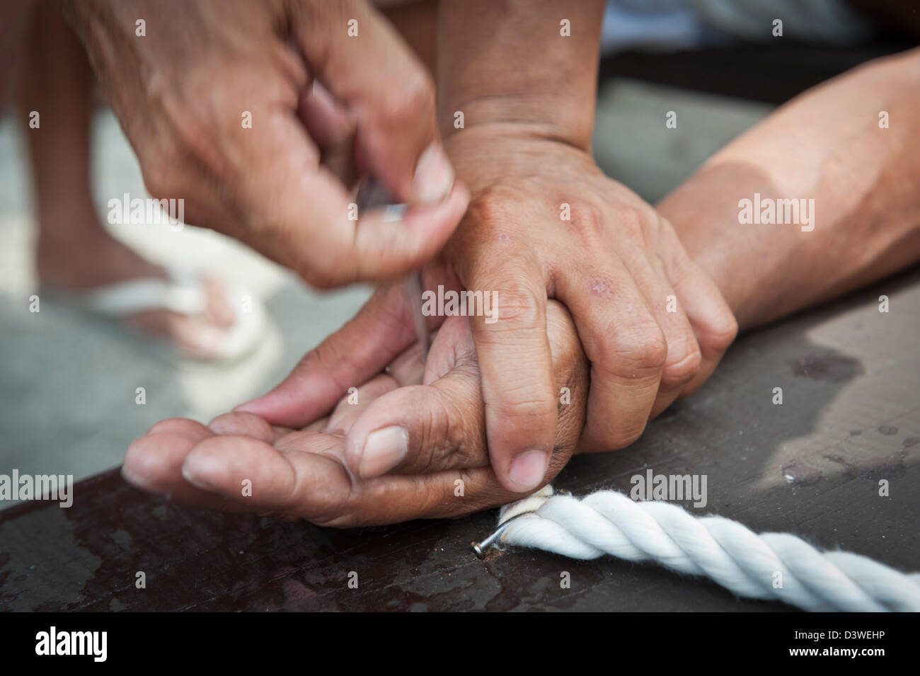 Detail von den Händen eines gekreuzigten Mannes während jemand ist die Nägel entfernen. San Fernando, Pampanga, Philippinen. Stockfoto