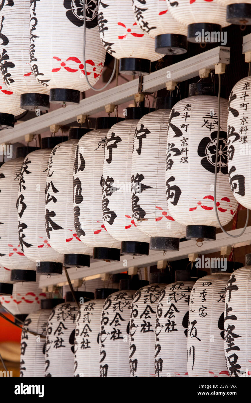 Traditionelle japanische Papierlaternen oder Chochin in einem Kyoto-Schrein jetzt oft beleuchtet von Elektrizität und die Steckdosen sind sichtbar. Stockfoto