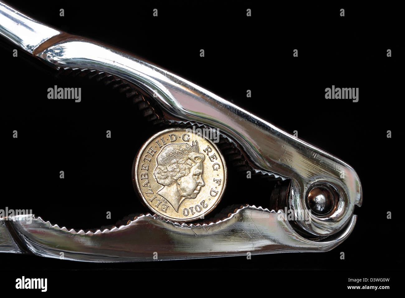 Pfund-Münze im Nussknacker auf dunklem Hintergrund Stockfoto