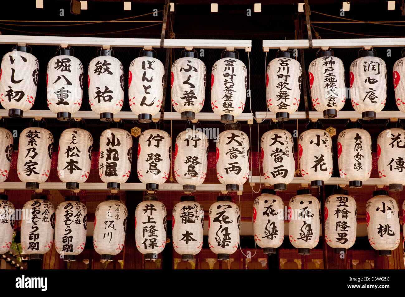 Traditionelle japanische Papierlaternen oder Chochin in einem Kyoto-Schrein jetzt oft beleuchtet von Elektrizität und die Steckdosen sind sichtbar. Stockfoto