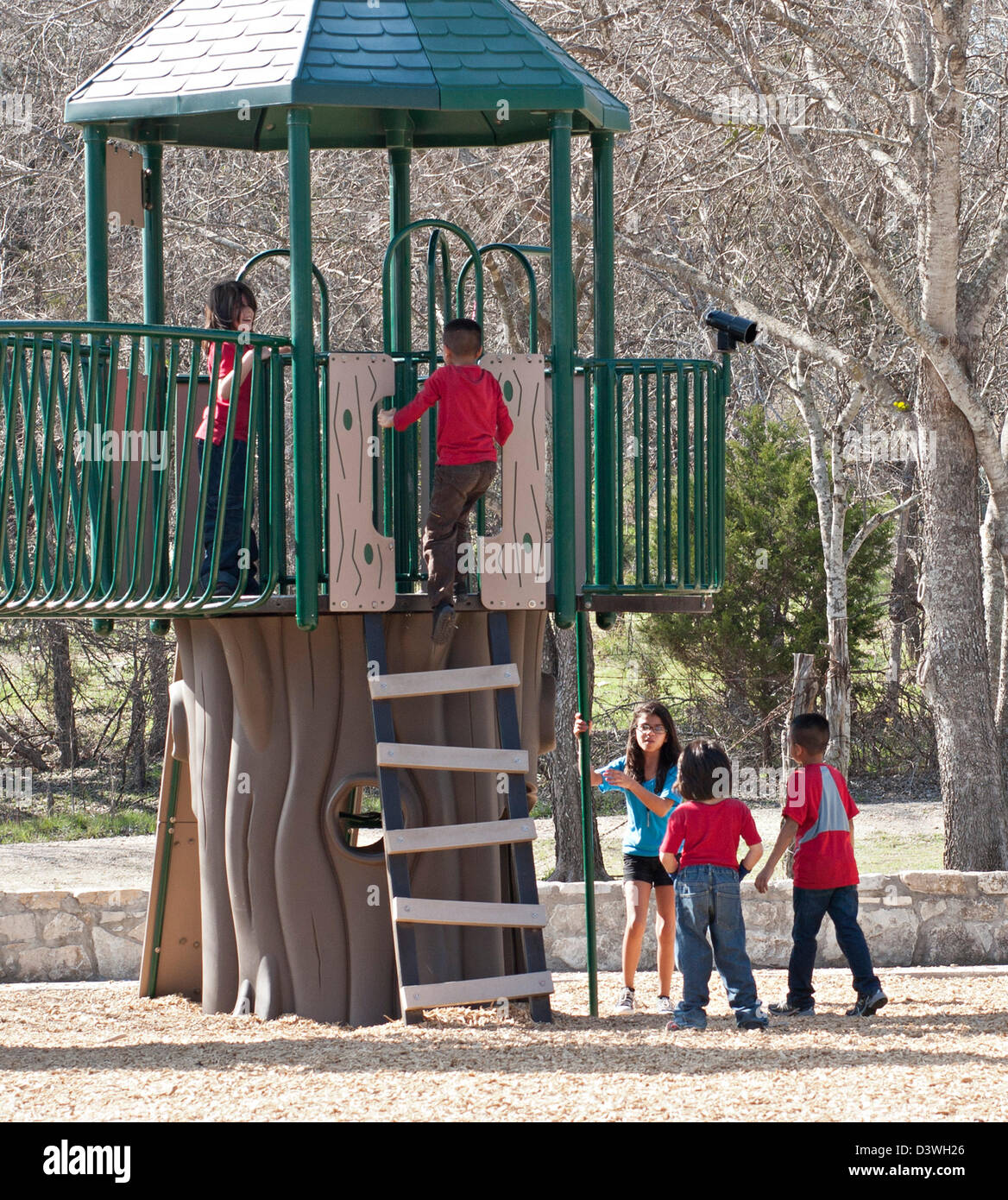 Einige Kinder spielen auf erhöhten Spielplatz Struktur in kommunalen öffentlichen Park Stockfoto