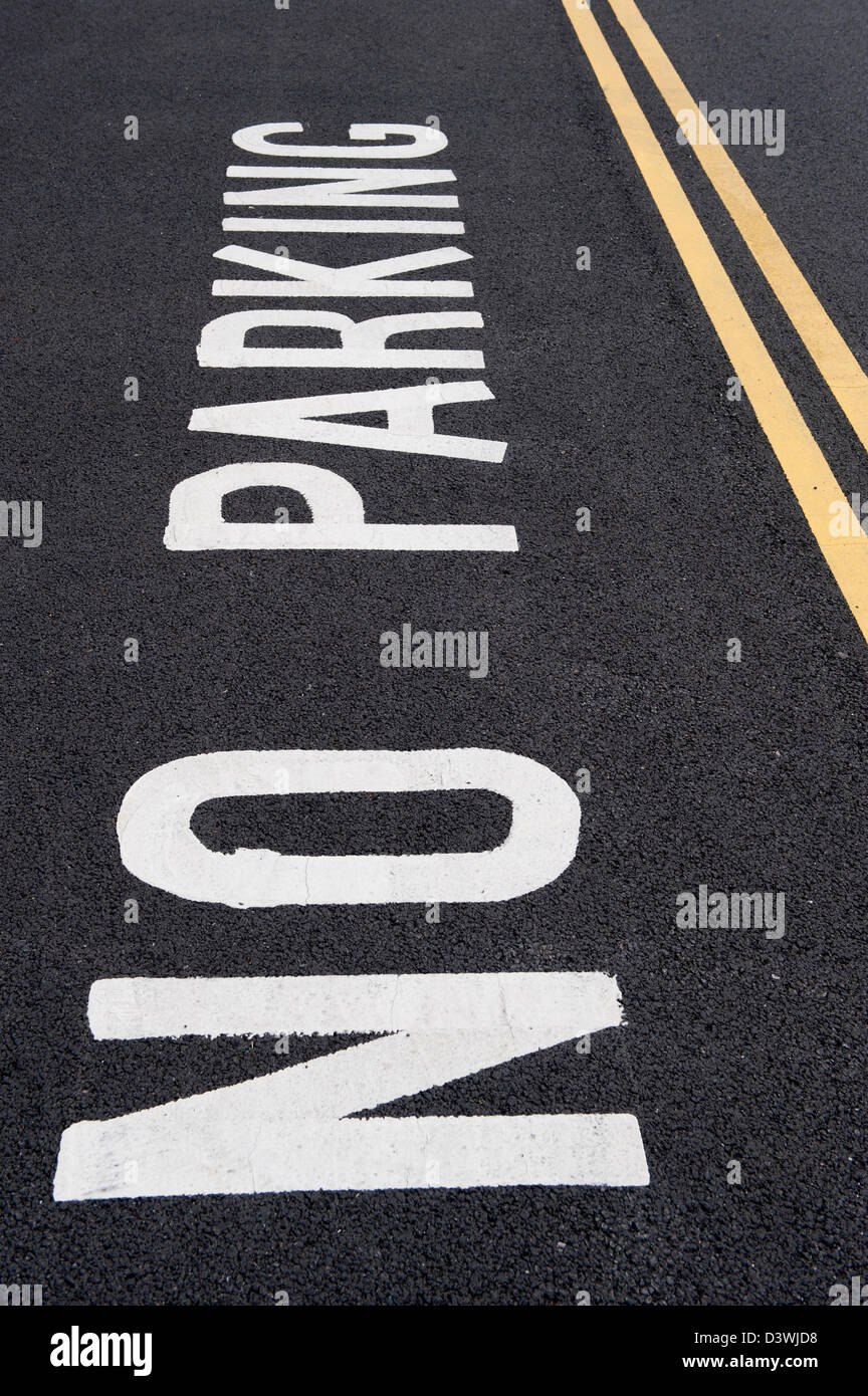 Kein Parkplatz Zeichen geschrieben auf Straße neben doppelte gelbe Linien Stockfoto