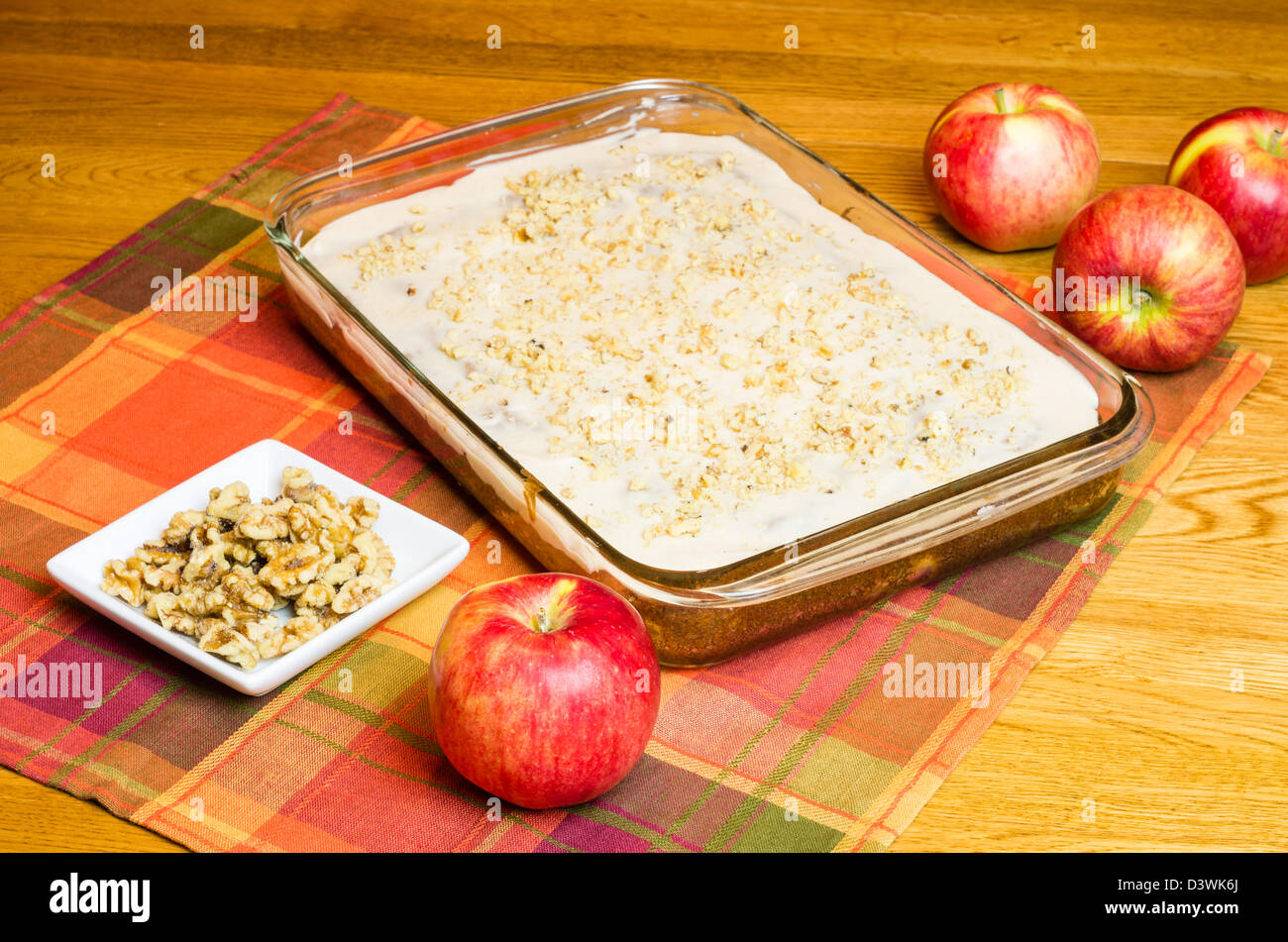Ein Apfelkuchen mit einem Teller mit Walnüssen und Äpfeln Stockfoto
