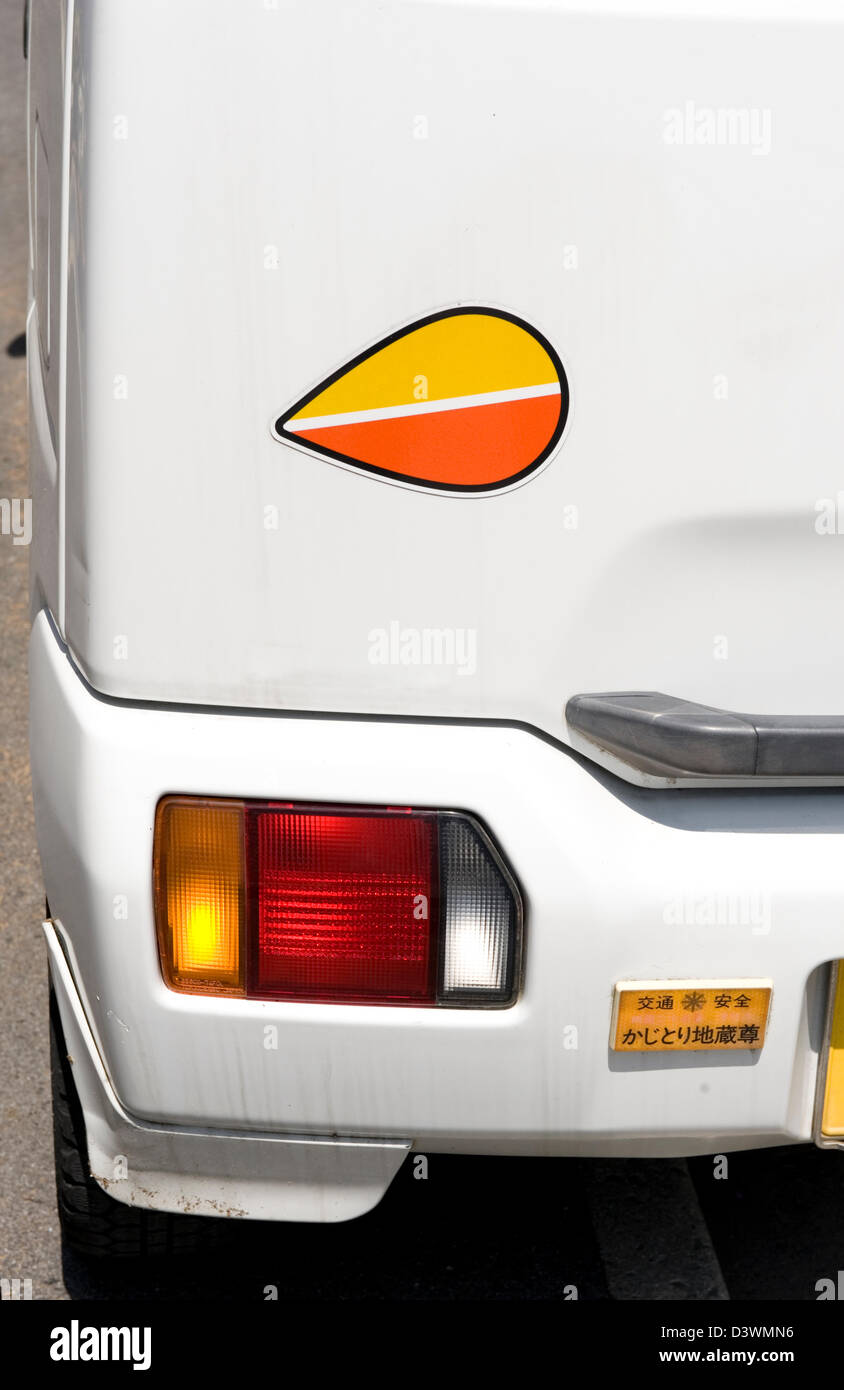 Orange und gelbe Träne Tropfen geformt Aufkleber auf Rückseite des japanischen Auto sagt andere Autofahrer, dass dieser Treiber ist ein Senior. Stockfoto