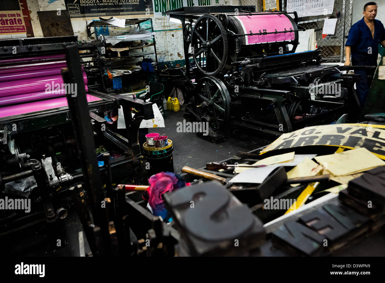 Eine Kolumbianische master Drucker bereitet die alten Buchdruck Maschinen für einen neuen Laden in der Druckerei in Cali, Kolumbien. Stockfoto