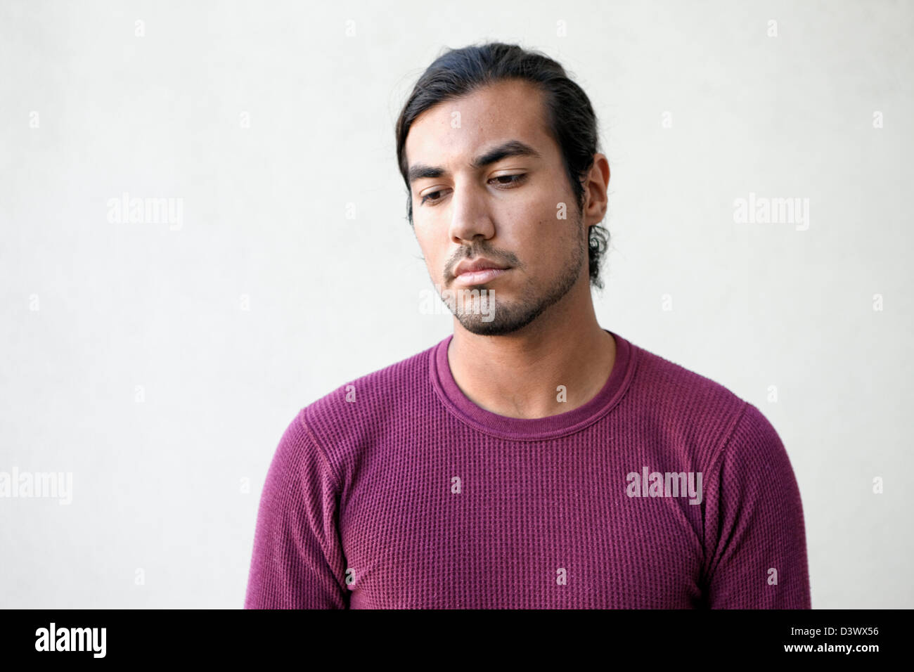 Porträt von traurig und deprimiert junger Erwachsener mexikanisch-amerikanischen Mann tief in Gedanken Stockfoto