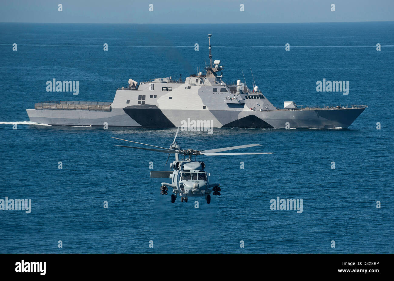 Ein MH-60R Seahawk-Hubschrauber fliegt vor dem littoral combat Schiff USS Freedom im Gange Durchführung von Probefahrten 25. Februar 2013 vor der Küste von Süd-Kalifornien. Freiheit, das Typschiff der Freiheit Variante des LCS, wird voraussichtlich in diesem Frühjahr nach Südostasien bereitstellen. Stockfoto