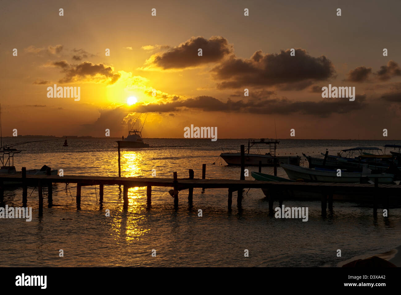 Orange Sonnenuntergang über einem Fischerhafen Pier in Isla Mujeres, Mexiko Stockfoto