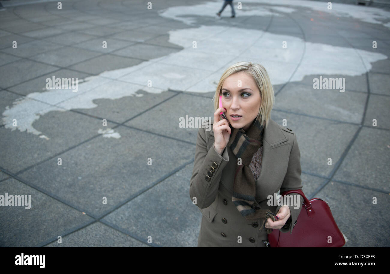 Frau am Handy auf große Weltkarte in Washington, D.C. Stockfoto
