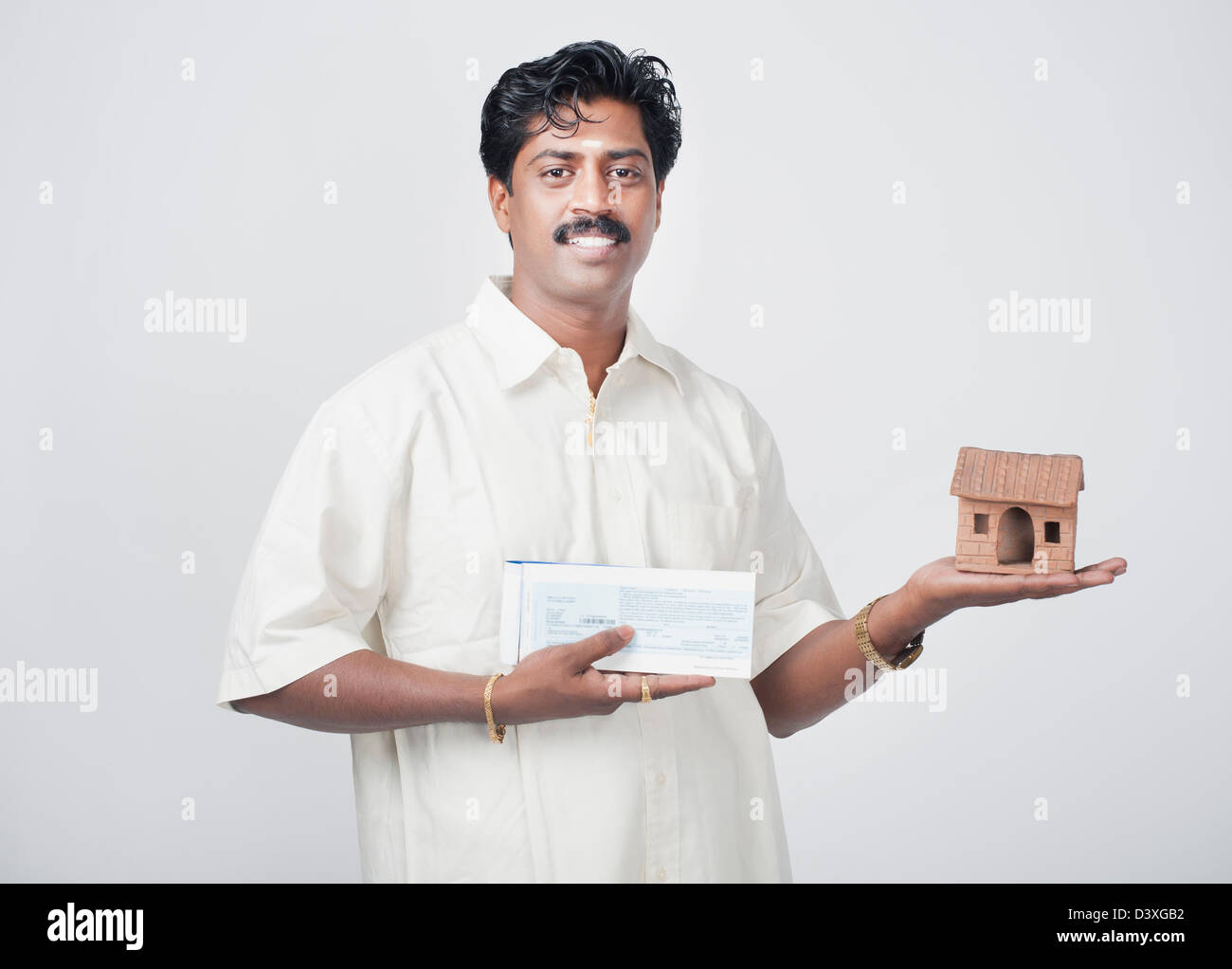 Südindische Mann, ein Modell zu Hause und ein Scheckbuch Stockfoto