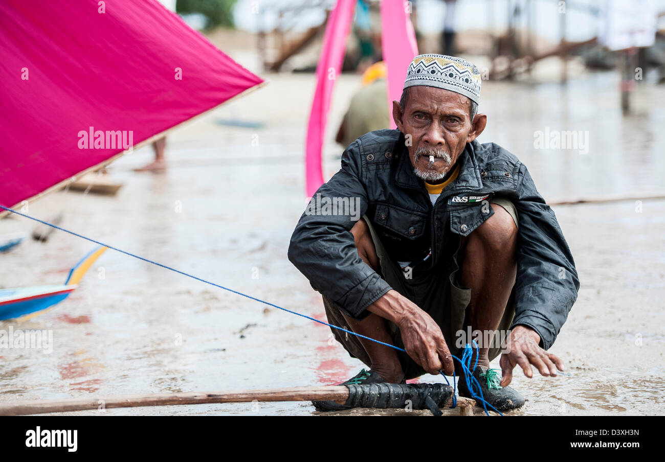 Ein Mann bereitet ein kleines Boot zu Segeln in Bintan, Indonesien Stockfoto