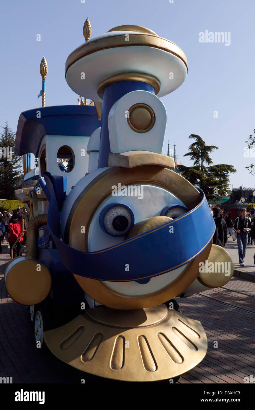 Eine Mini unter dem Motto Parade, angeführt von einer Lokomotive, Modell geht vor der Cinderella Castle im Disneyland Paris Stockfoto