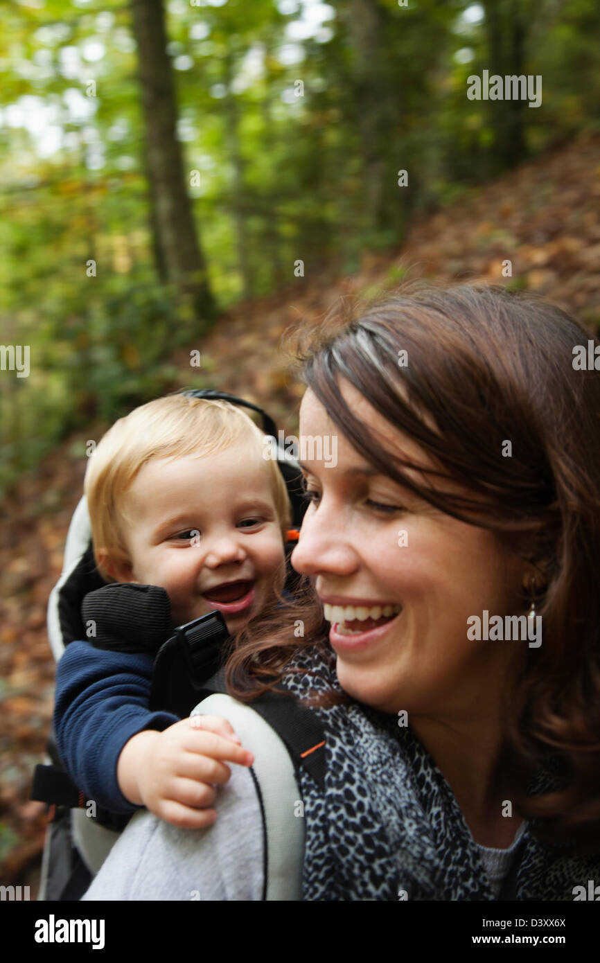 Kaukasische Mutter mit Kleinkind auf Rücken Stockfoto