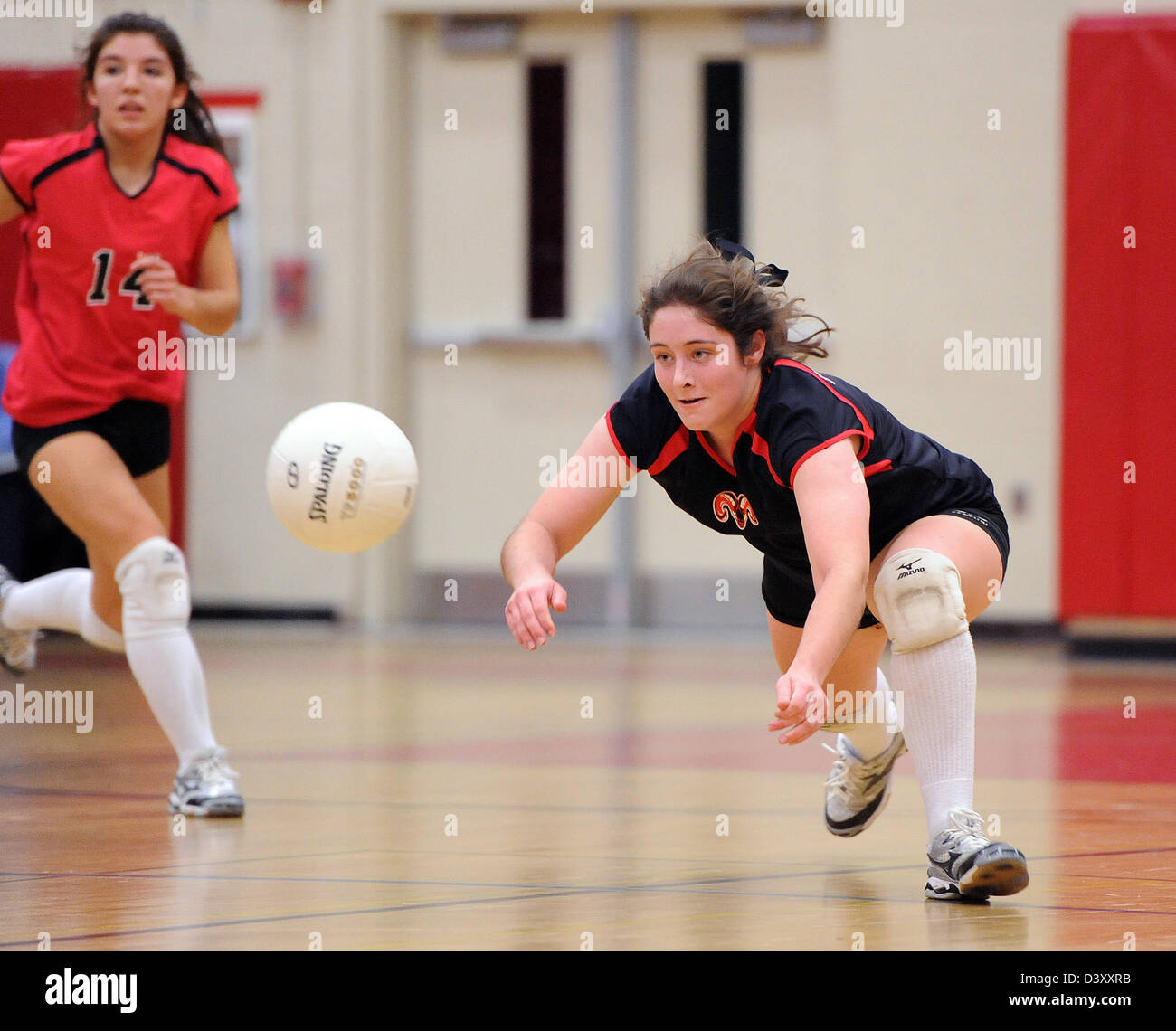 Ein Spieler gräbt sich eine Spitze während der Mädchen-High School Volleyball Meisterschaftsspiel, CT USA Stockfoto