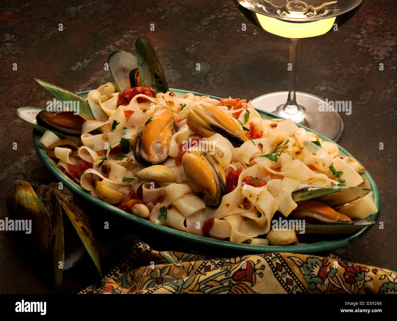 Eine Pasta-Teller mit grüne Muscheln, Tagliatelle Pasta, Knoblauch, Cannelini Bohnen und italienische Petersilie, begleitet von Weißwein... Stockfoto