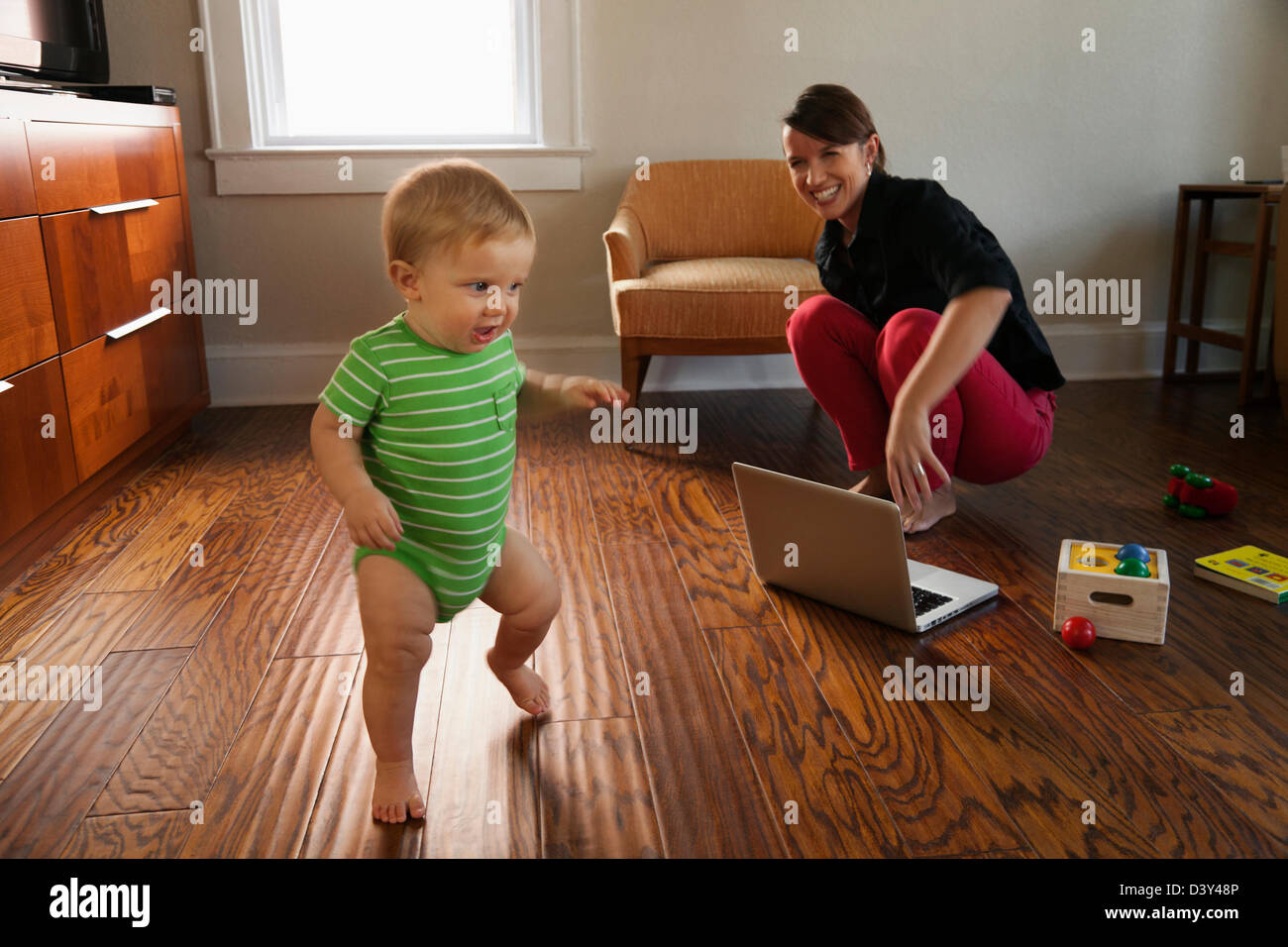 Kaukasische Mutter beobachtete Kleinkind Sohn zu Fuß Stockfoto