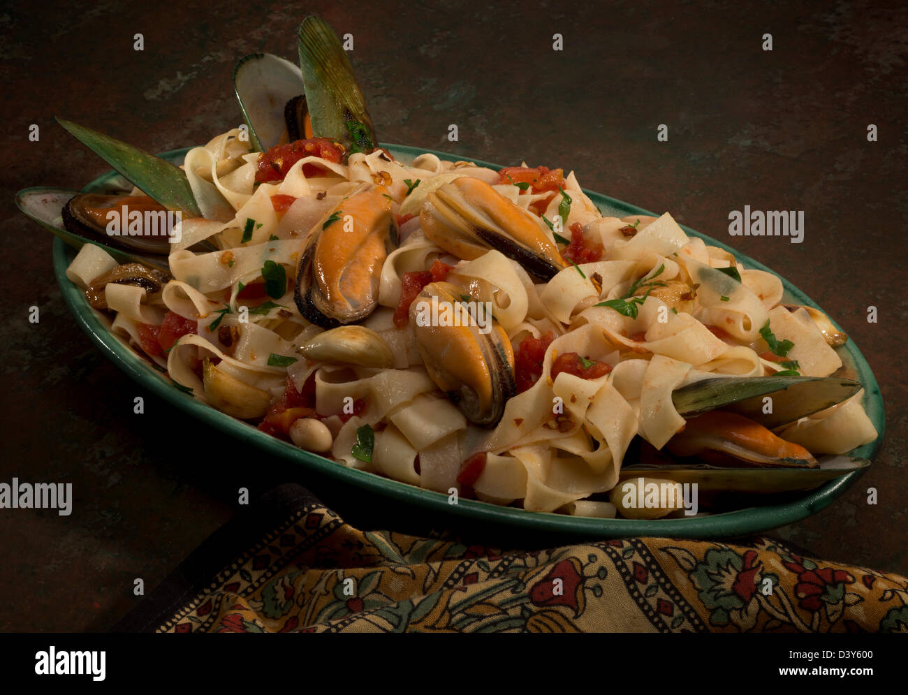Eine grüne Muschel-Platte mit Tagliatelle Pasta, Cannelini Bohnen, Knoblauch und italienische Petersilie. Stockfoto