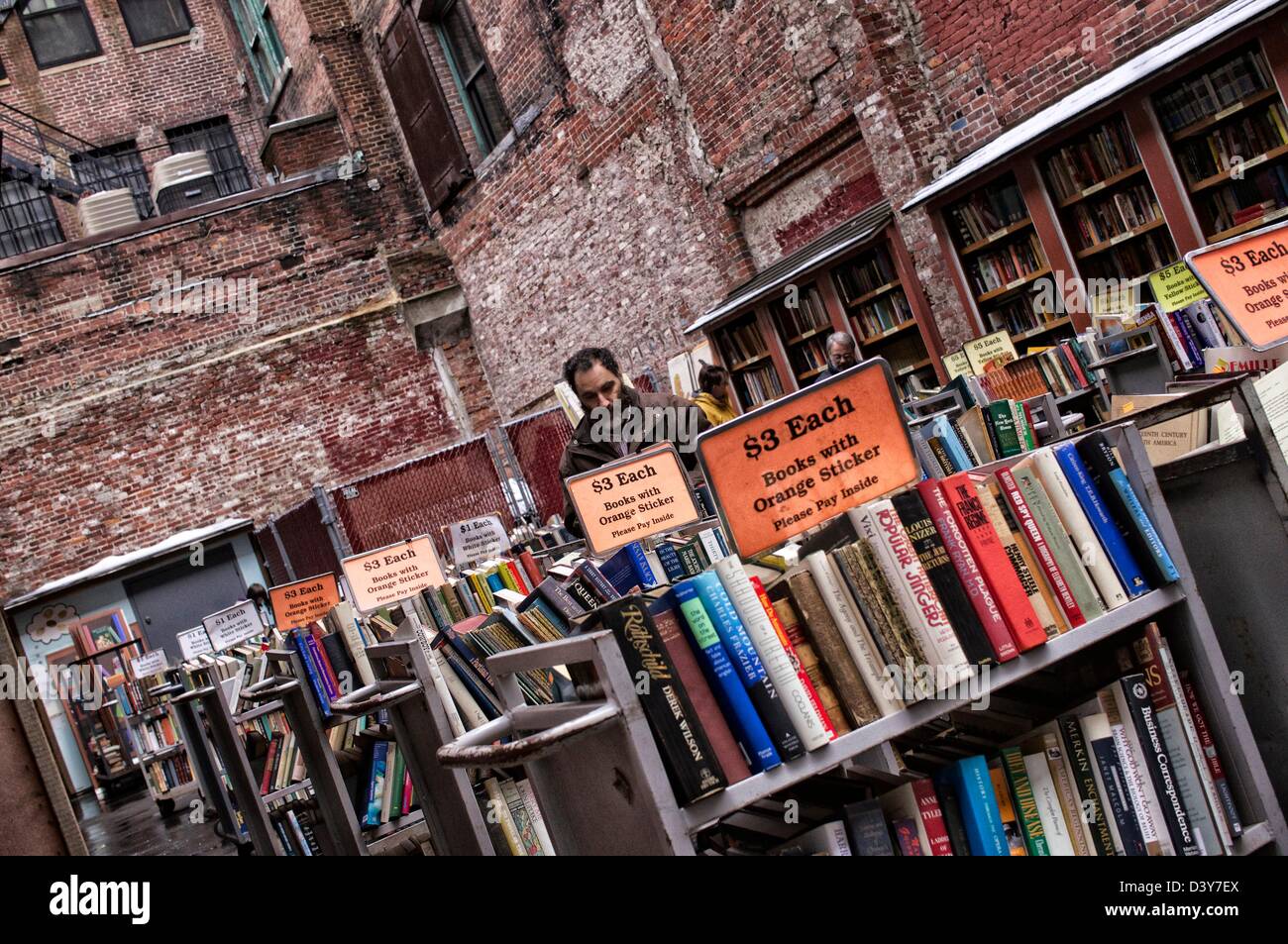 Outdoor-Buchhandlung mit bärtigen männlichen Verlader, die Bücher in der Nähe von Rückseite Store im New England Winter anschauen. Stockfoto