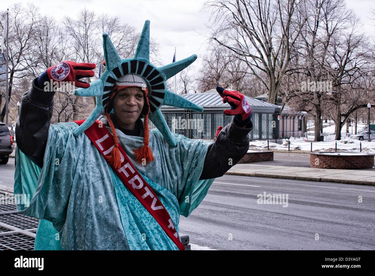 Ein junger Mann gekleidet wie die Statue of Liberty hocking für Liberty Steuerdienst. Stockfoto