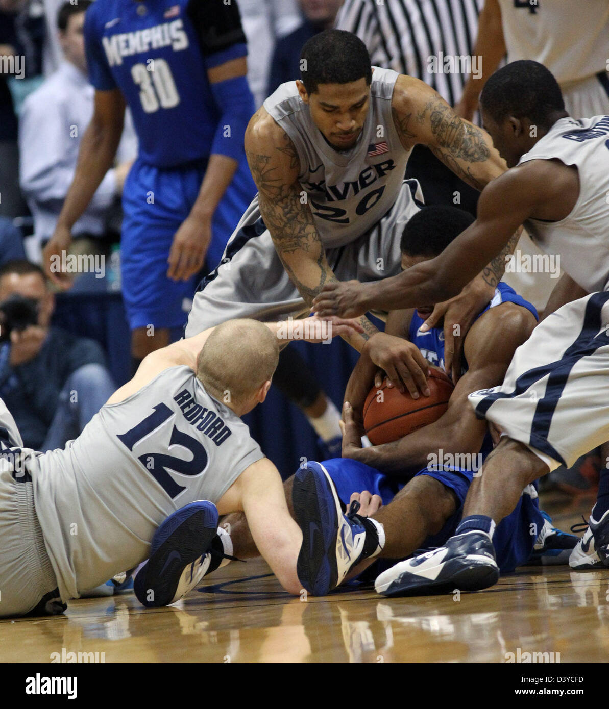 26. Februar 2013 - Cincinnati, Ohio, USA - Xavier Musketeers Spieler BRAD REDFORD (12), JUSTIN MARTIN (20) und TRAVIS TAYLOR (4) versuchen ihr Bestes, einem Ball aus Memphis Tigers Wache GERON JOHNSON (55) in der zweiten Hälfte des Spiels in der Mitte der Cintas nehmen. (Kredit-Bild: © Ernest Coleman/ZUMAPRESS.com) Stockfoto