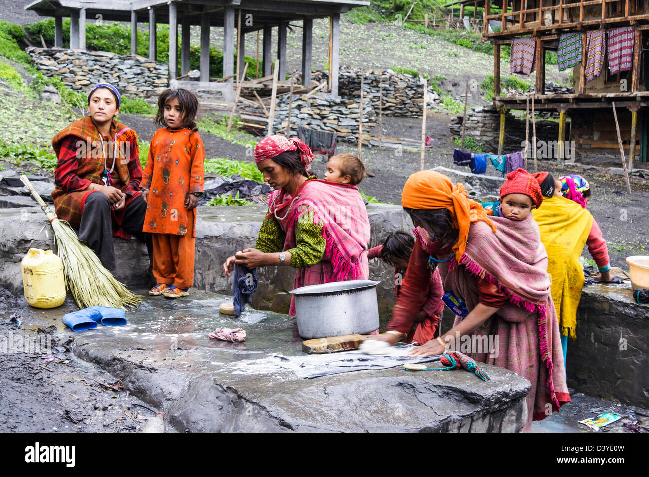 Frauen mit Kindern, die Wäsche machen. Malana Dorf, Himachal Pradesh, Indien Stockfoto