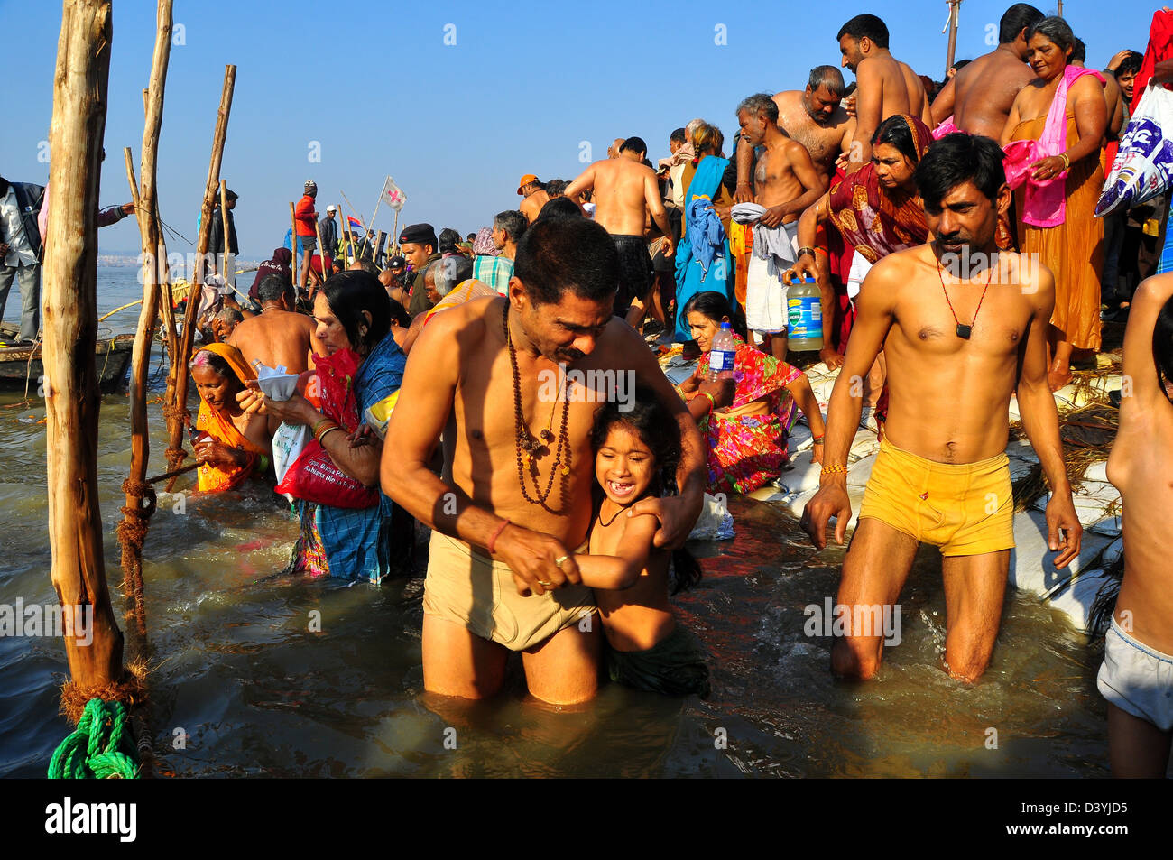 Vater mit seiner Tochter nehmen ein heiliges Bad am Ufer der Sangam Zusammenfluss von Ganges, Yamnuna und mythischen Saraswati. Stockfoto