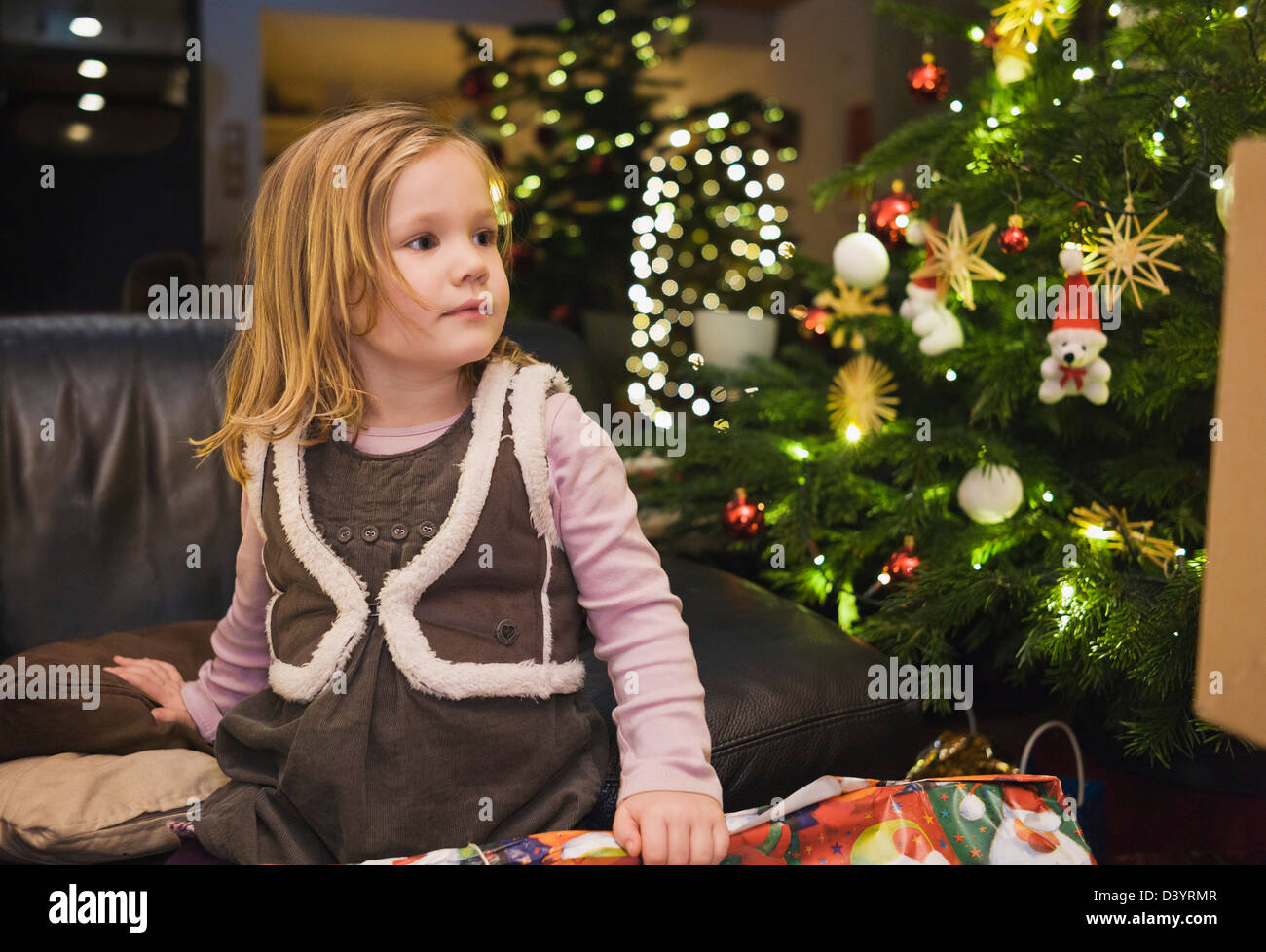 Mädchen auf zu Hause mit Weihnachtsbaum, Deutschland Stockfoto