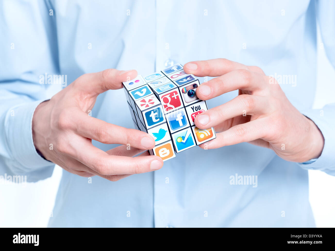 Geschäftsmann Lösung Rubiks Cube mit Logos von bekannten social-Media-Marke. Stockfoto