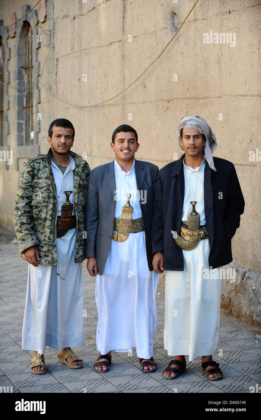 Drei Yemani Männer auf den Straßen von Sana ' a, Kapital Stadt von Jemen. Tragen traditionelle Kleidung mit traditionellen Messer, die Jambiyya Stockfoto