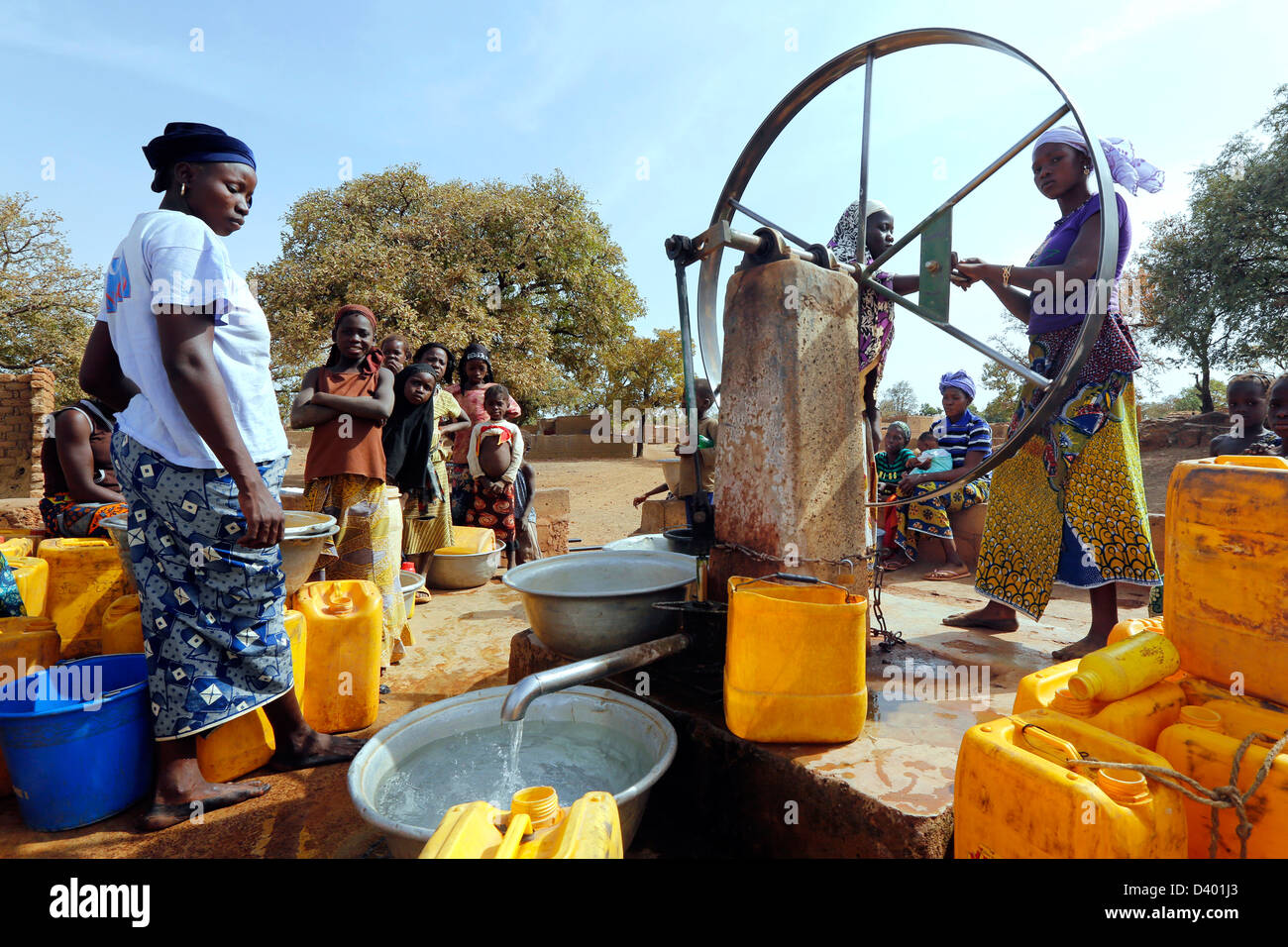 Frauen versammeln sich, um die Wasserpumpe am Dorf, Burkina Faso, Afrika Stockfoto