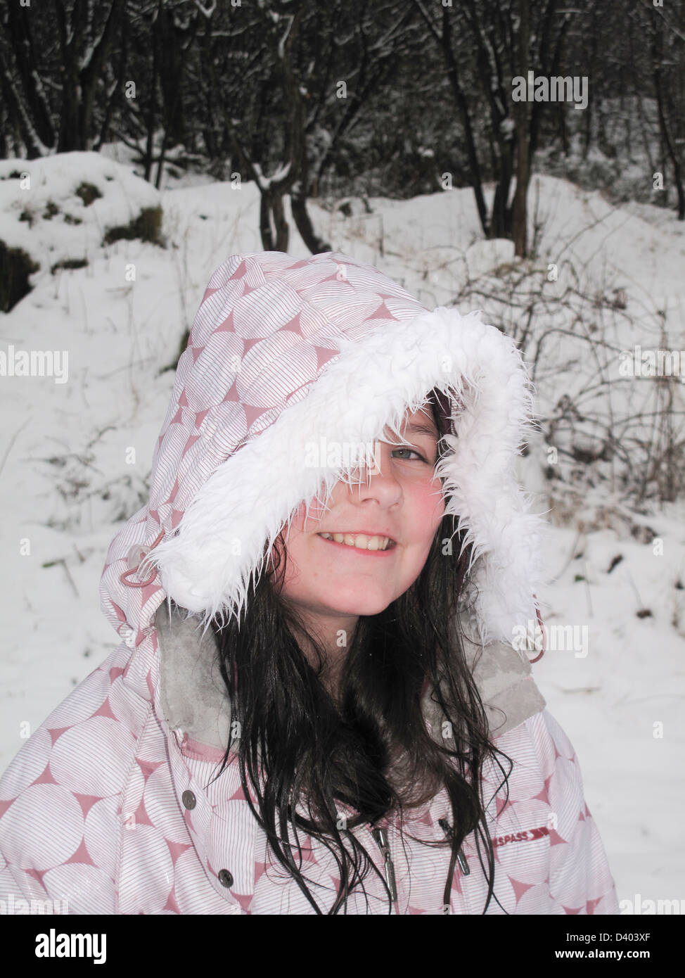 Junges Mädchen im Pelz gefüttert Skijacke im Schnee Stockfoto