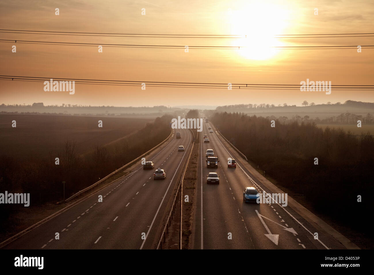 Autos fahren auf der A14 zweispurigen Straße in Cambridgeshire bei Sonnenuntergang, England UK Stockfoto