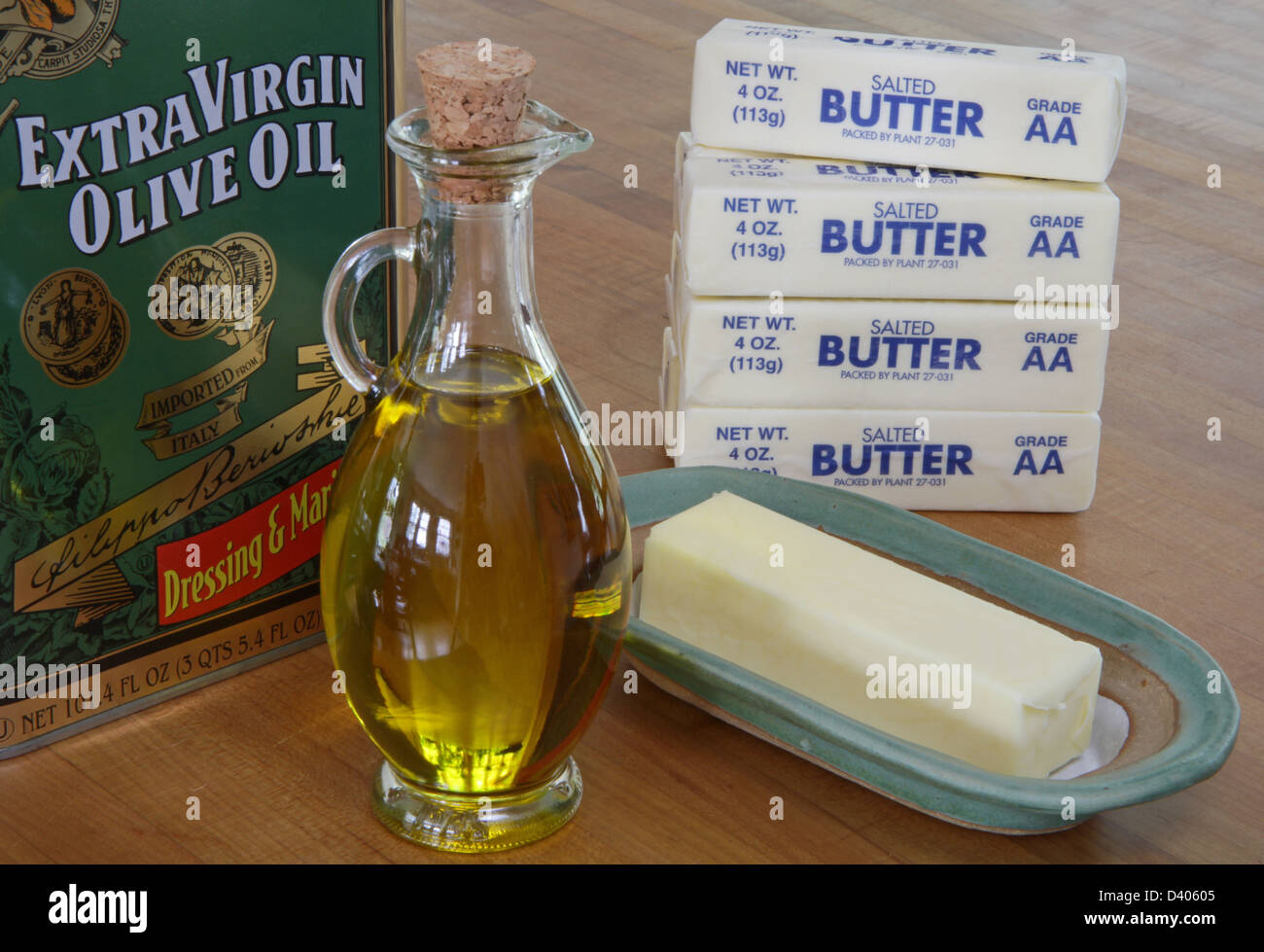 Olivenöl und Butter. Olivenöl, eine einfach ungesättigte Fette, ist bei Raumtemperatur flüssig. Butter, eine gesättigte Fettsäuren, ist solide. Stockfoto