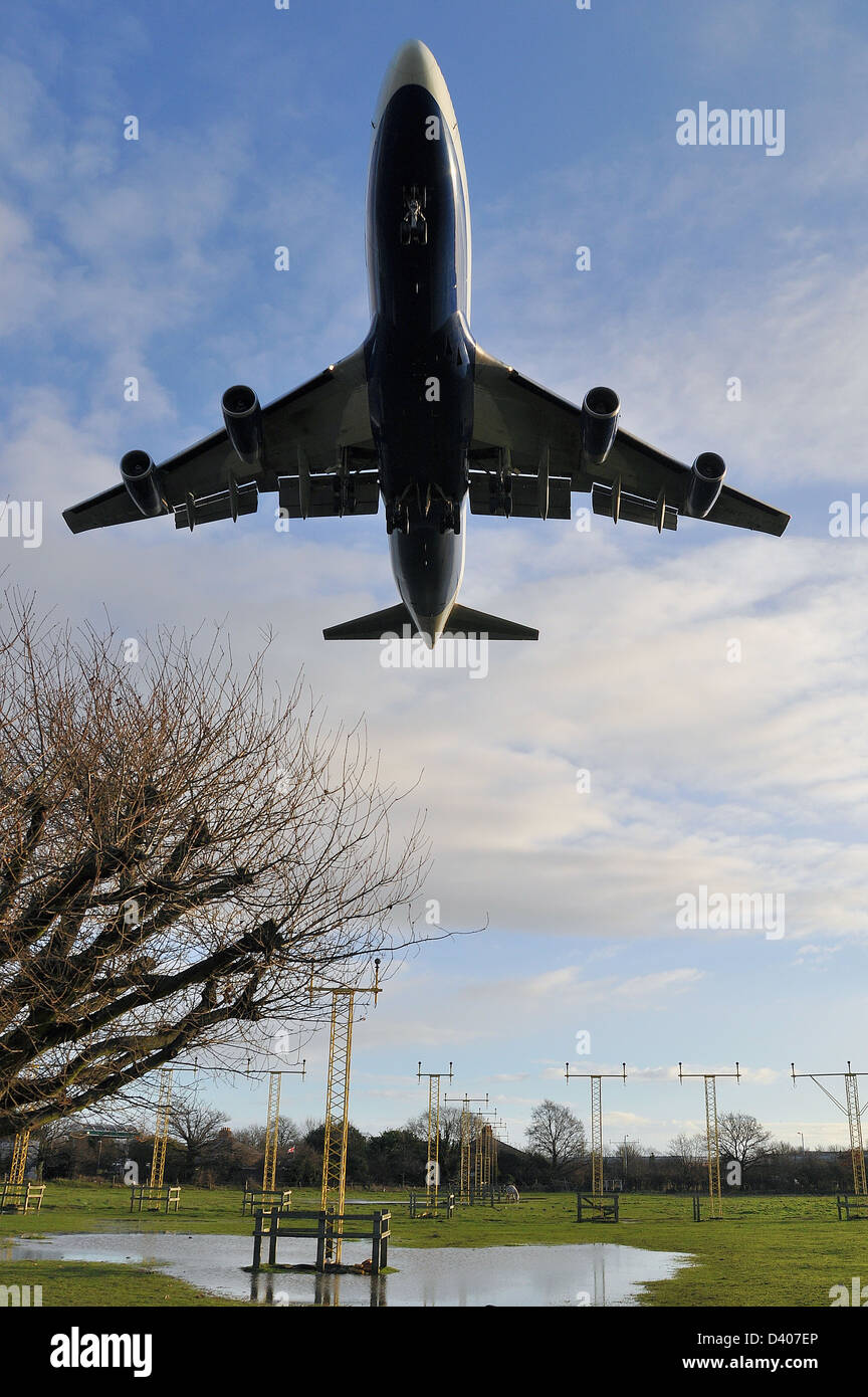British Airways Boeing 747 Jumbo Jet landet am London Heathrow Airport tief über den Landungslichtern und überfluteten Feldern Stockfoto