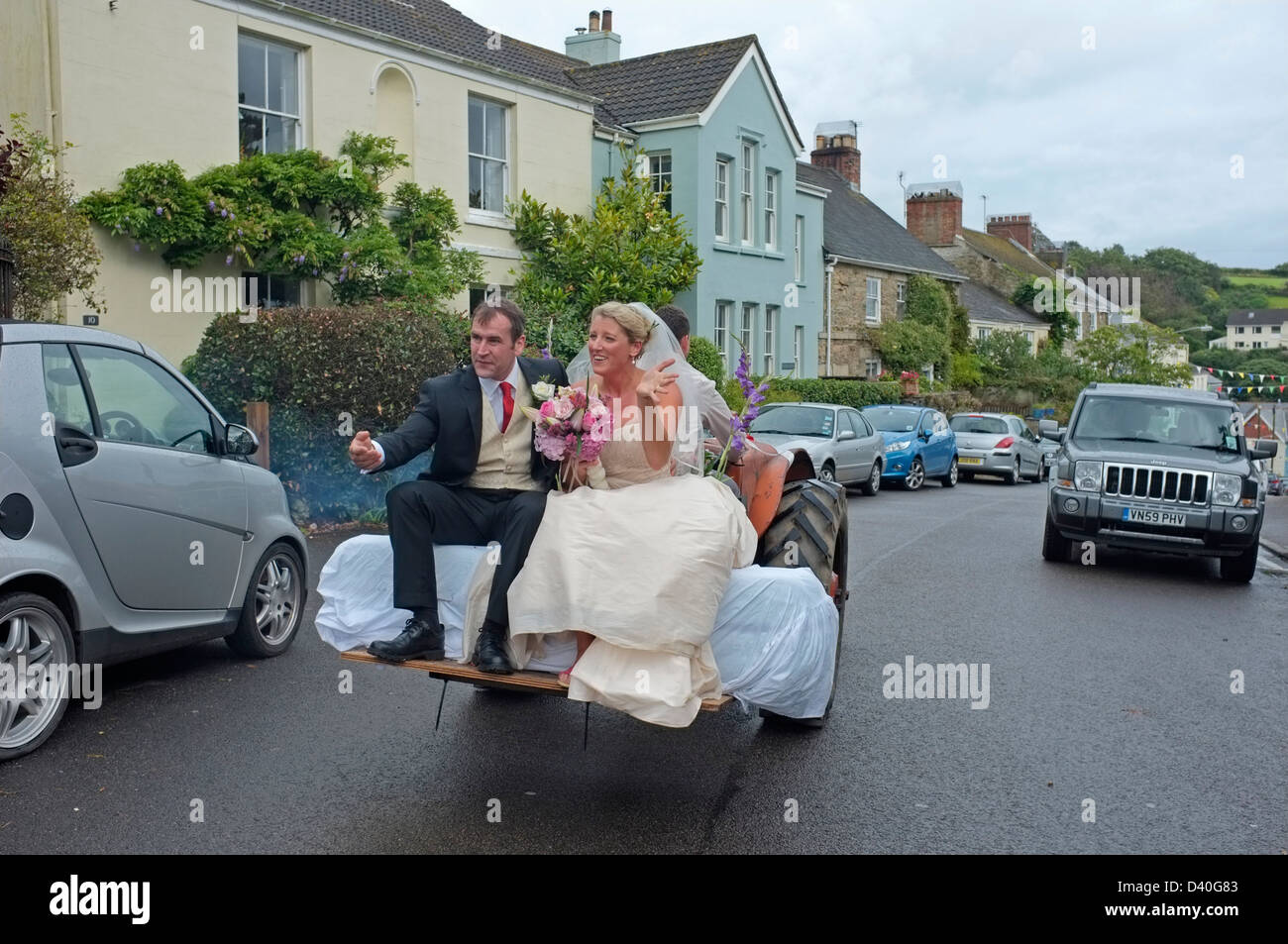 Ein frisch verheiratetes Paar die Kirche verlassen auf einem Traktor. Stockfoto