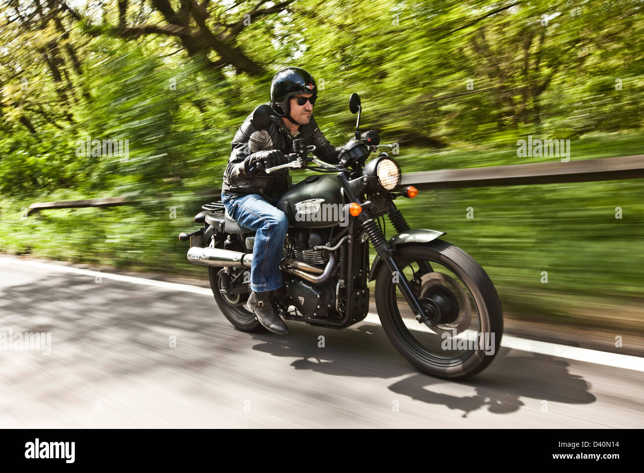 Mann in schwarz Leder mit Triumph Scrambler Motorrad, London Stockfoto