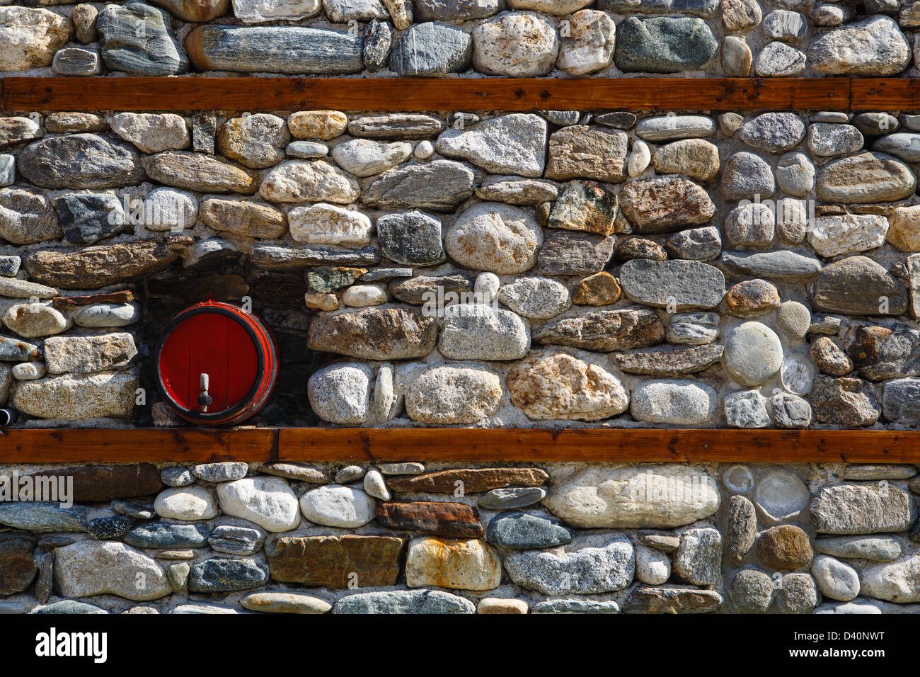 Steinmauer mit einem Fass als dekoratives element Stockfoto
