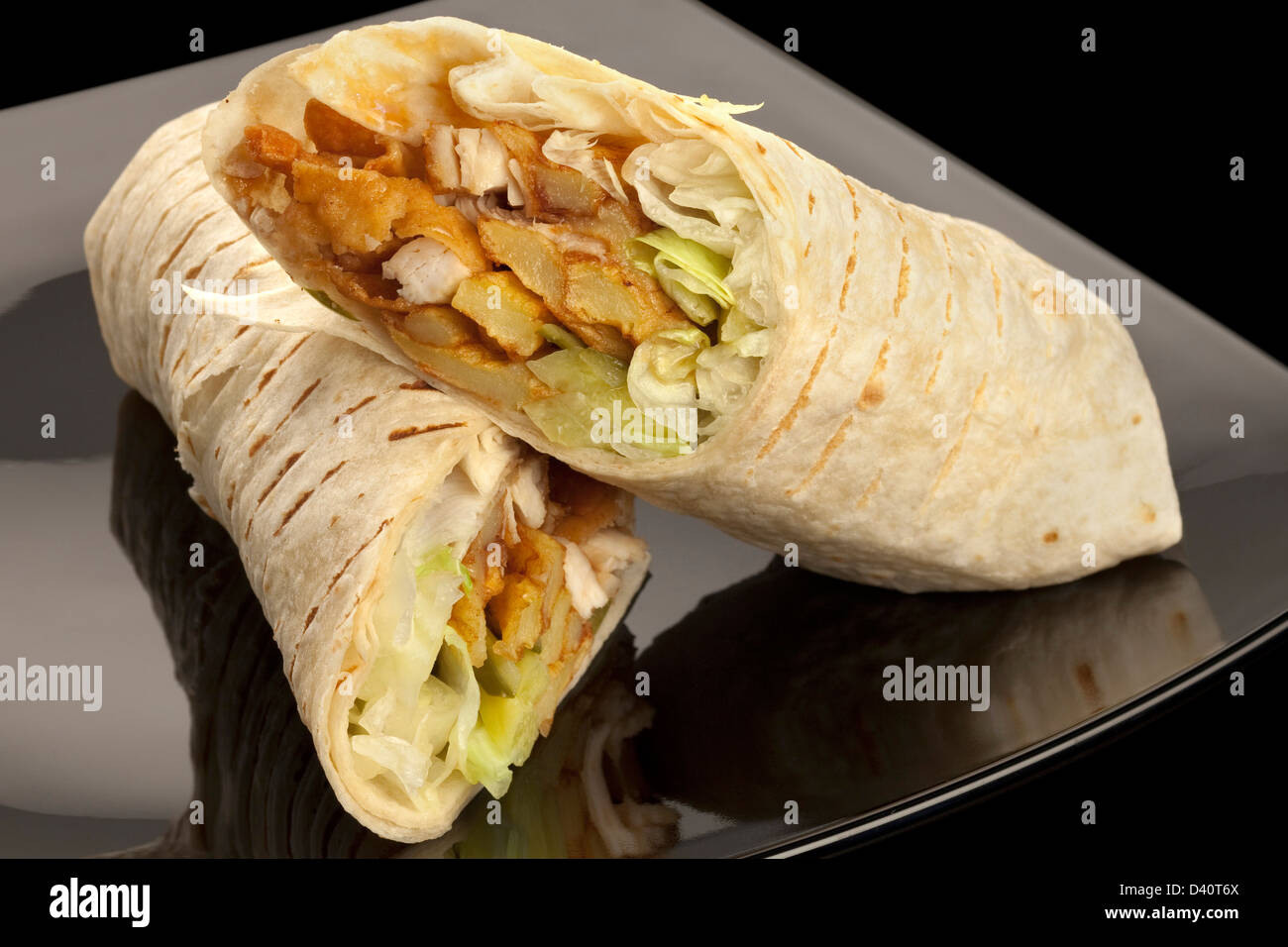 Tortilla mit Huhn und Gemüse auf schwarzem Teller Stockfoto