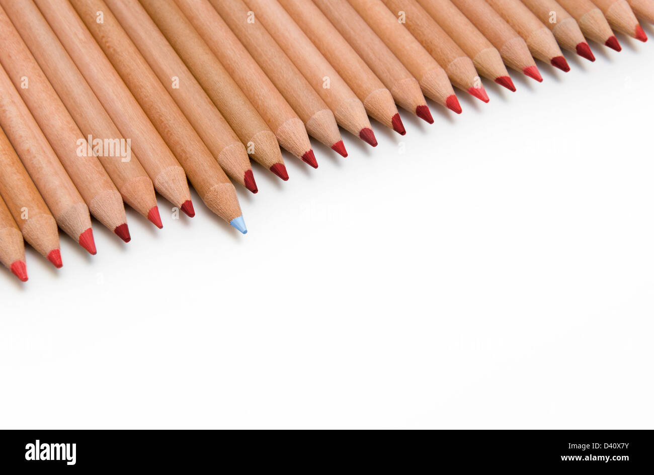 Linie der roten Buntstifte mit einem blauen Stift, die herausragen - Unterschied-Konzept Stockfoto