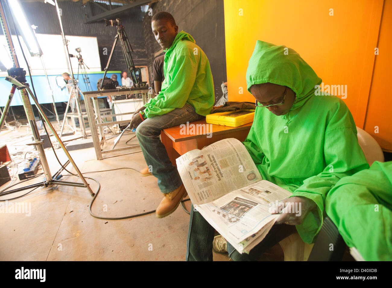 Nairobi, Kenia. 26. Februar 2013. Puppenspieler in Greenscreen Outfit eine Pause und liest eine Zeitung zwischen den Szenen während der Wahl Spezialsendung von der kenianischen Polit-Satire "XYZ-Show" schießen. Die Show bietet eine Spoof Nachrichtensendung von Latex Puppen. Stockfoto