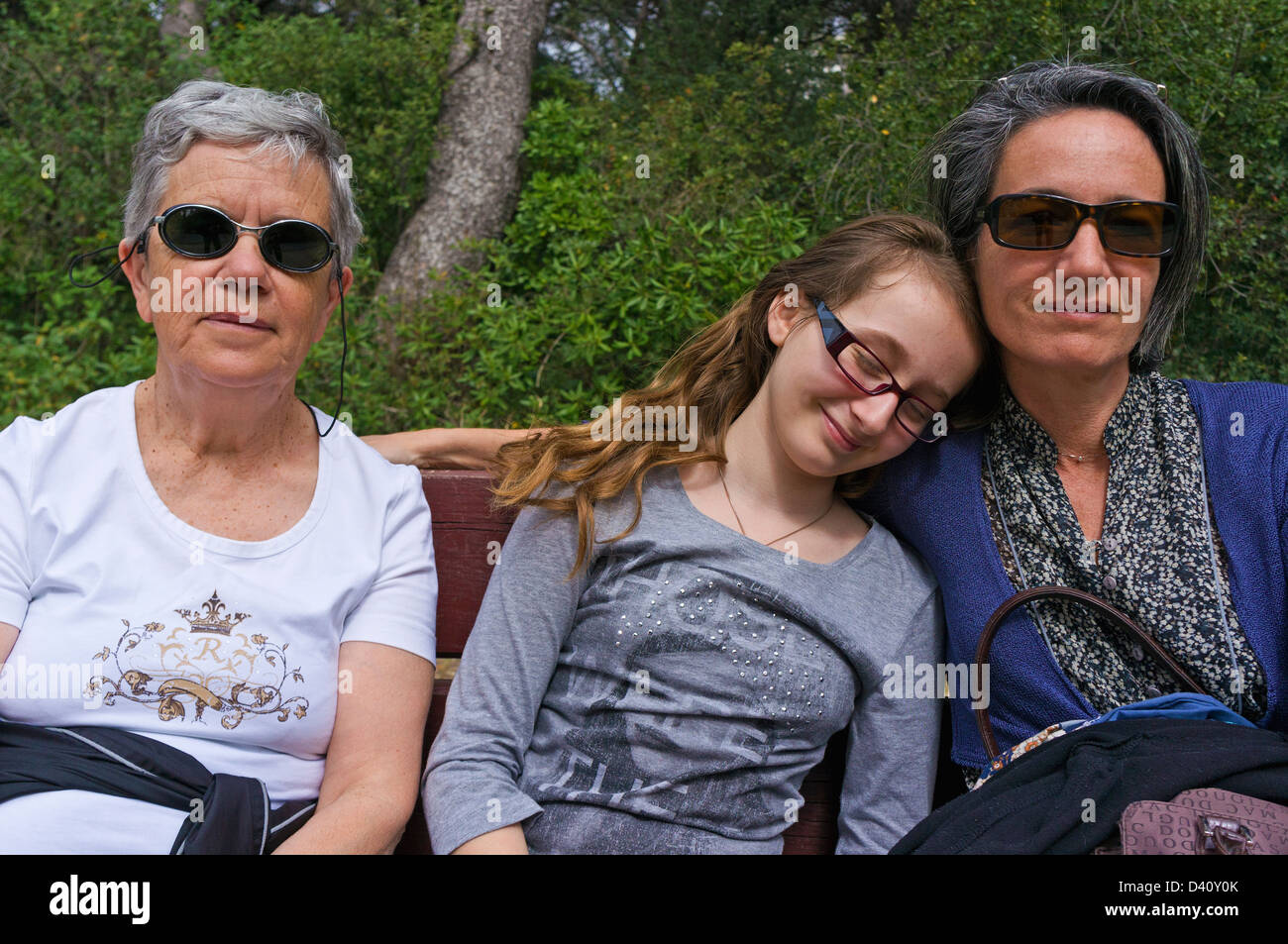 Familiengruppe Porträt - Senior Frau, Tochter und Enkelin ruht auf Bank in einem öffentlichen park Stockfoto