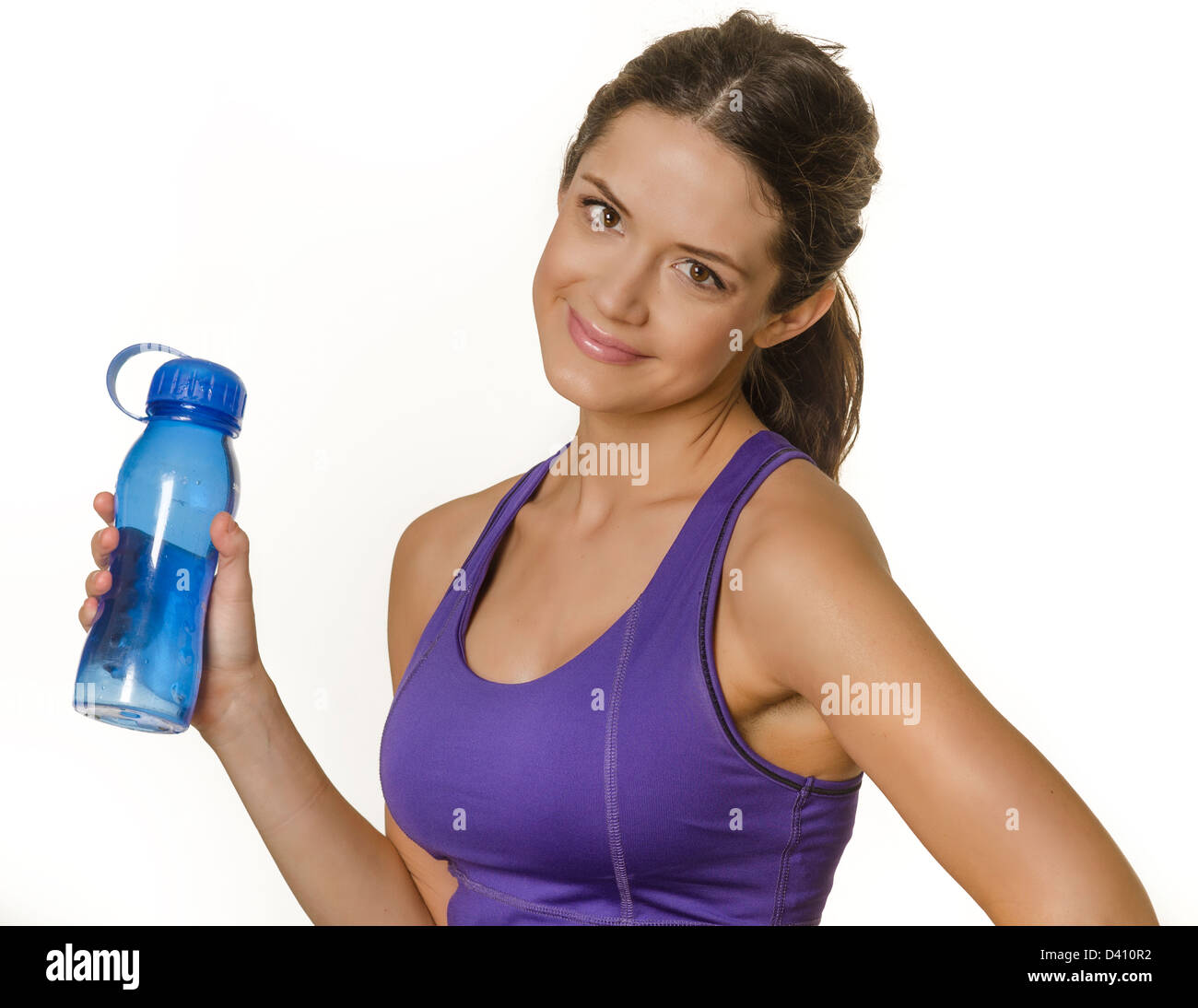 Hübsche junge Frau hält eine Flasche Wasser in Sportkleidung. Isoliert gegen weiß. Stockfoto